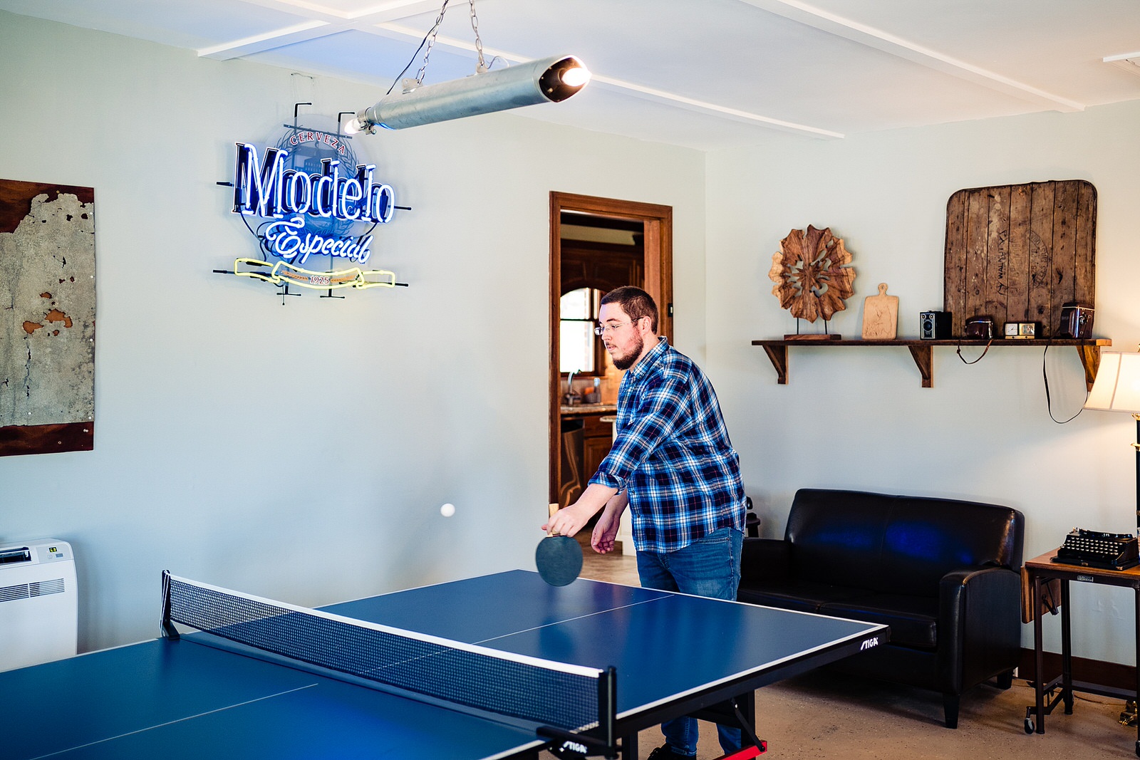 Groom plays ping pong before getting ready for his wedding at The Meadows Raleigh