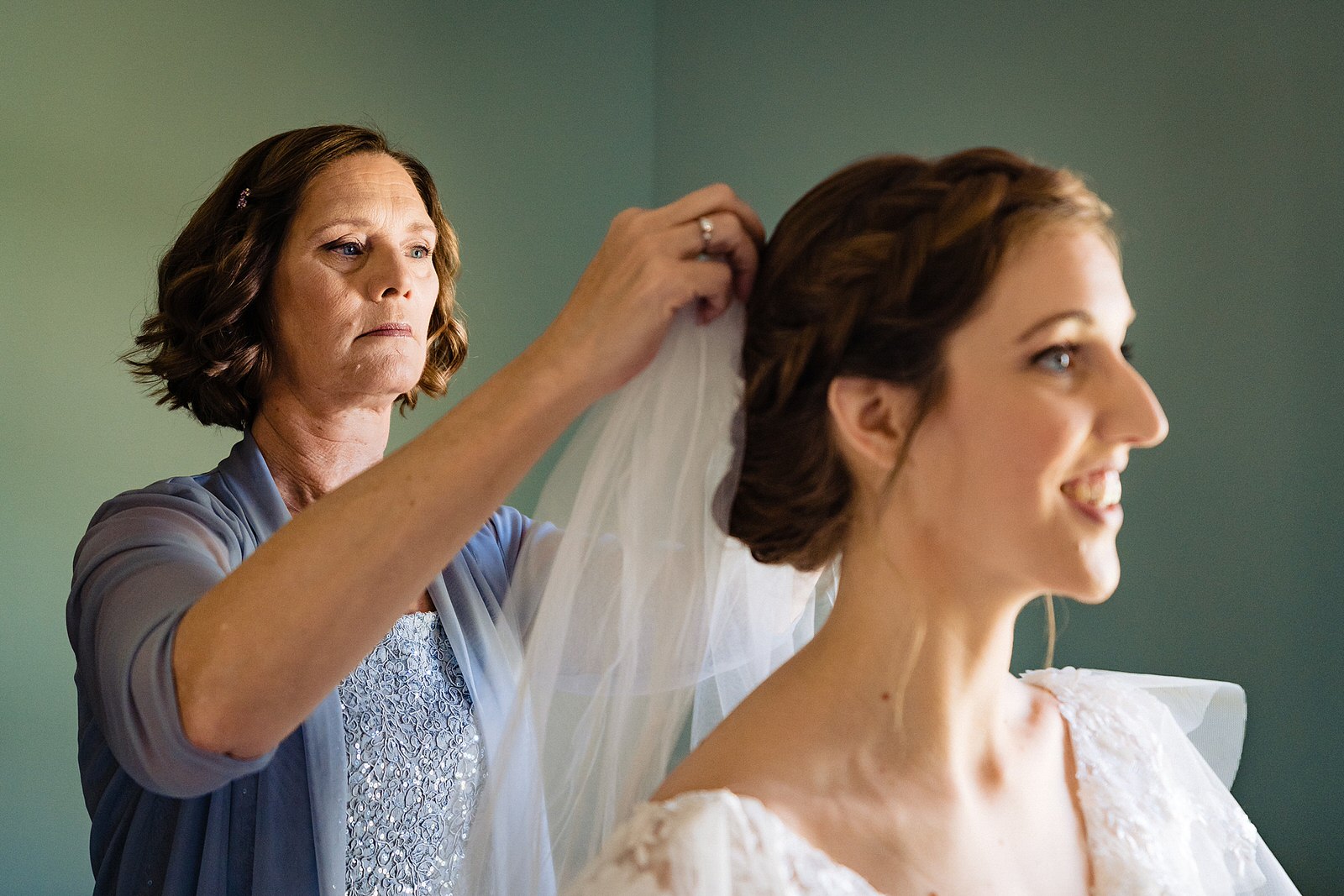 Bride's mother helps her put on her veil, by Raleigh wedding photographers