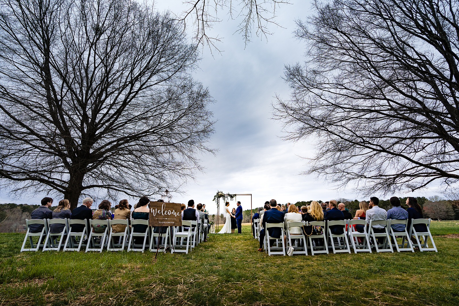 Outdoor wedding ceremony on the lawn of Aerie House at The Meadows Raleigh by Raleigh wedding photographers