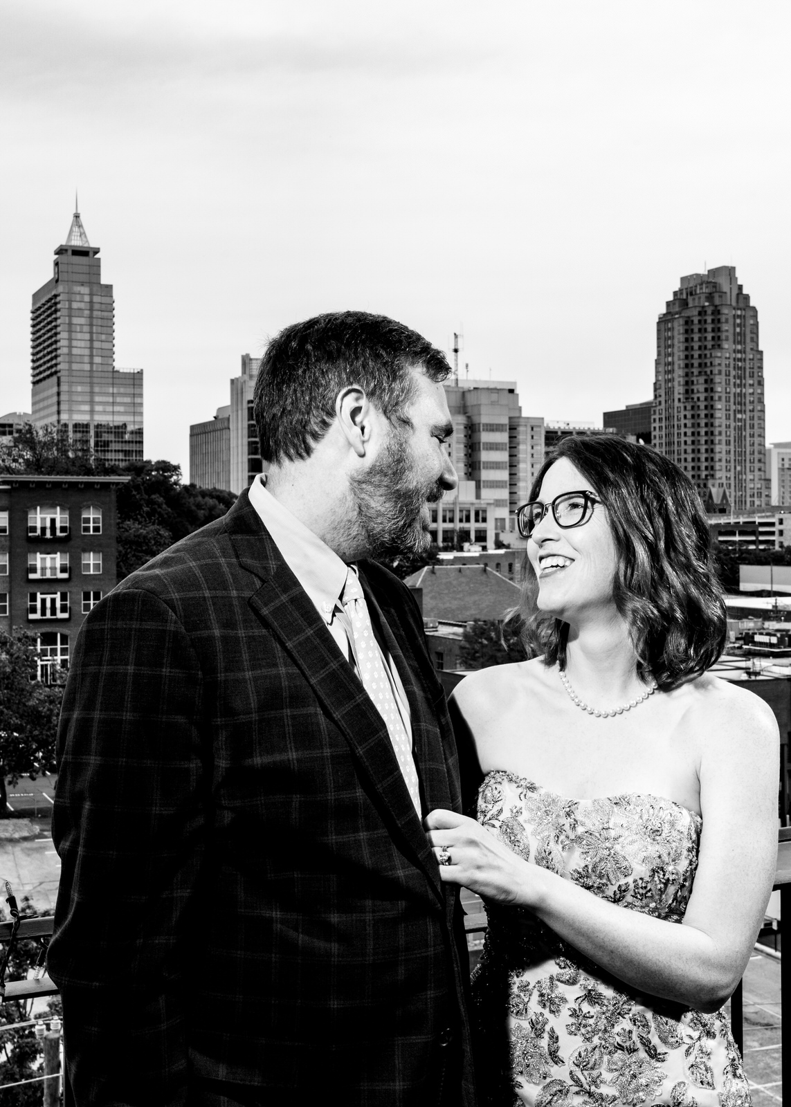 Bride and groom pose with the downtown raleigh skyline as part of the big fake quarantine wedding project