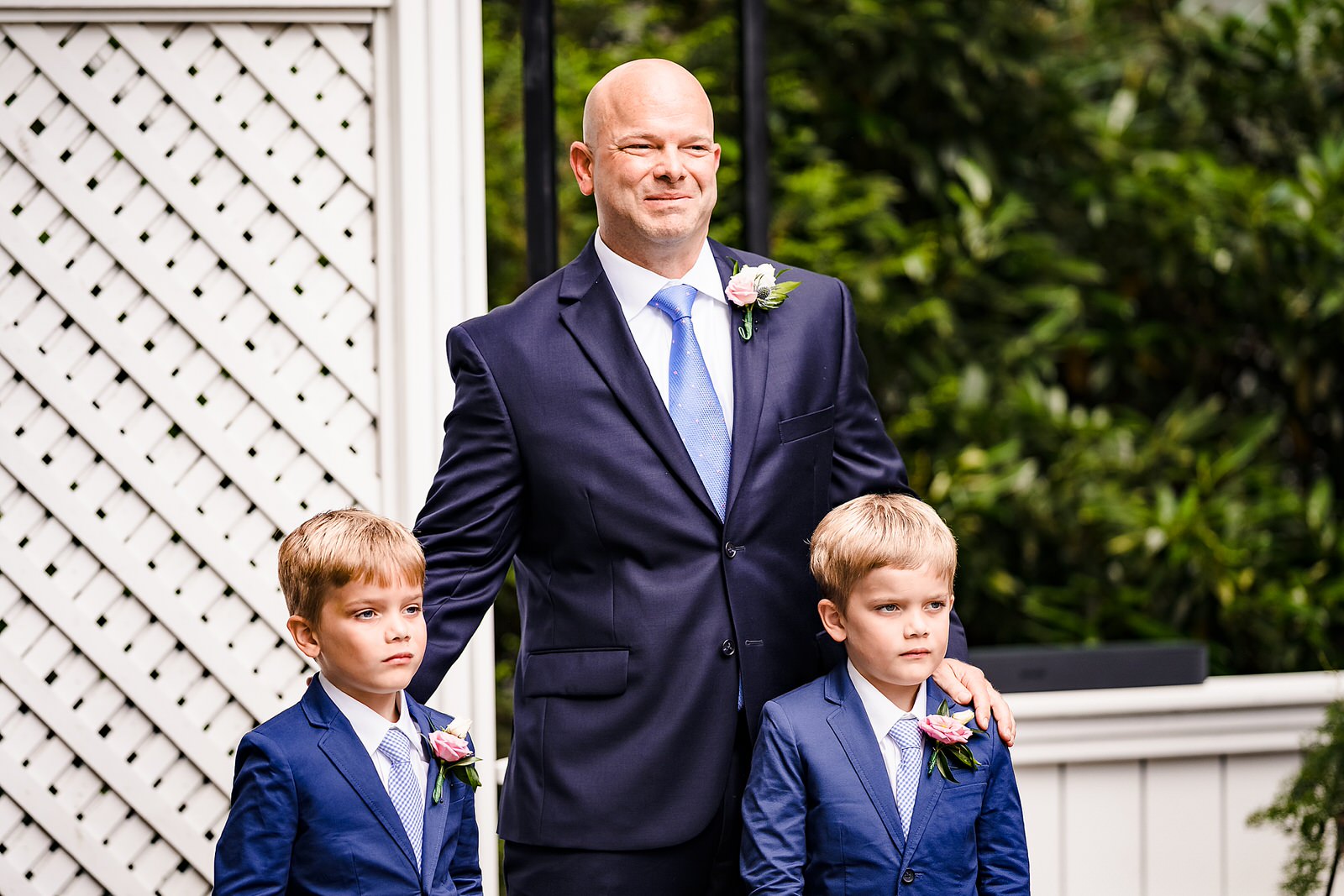 Groom stands with his sons at front of ceremony waiting for bride to walk down the aisle