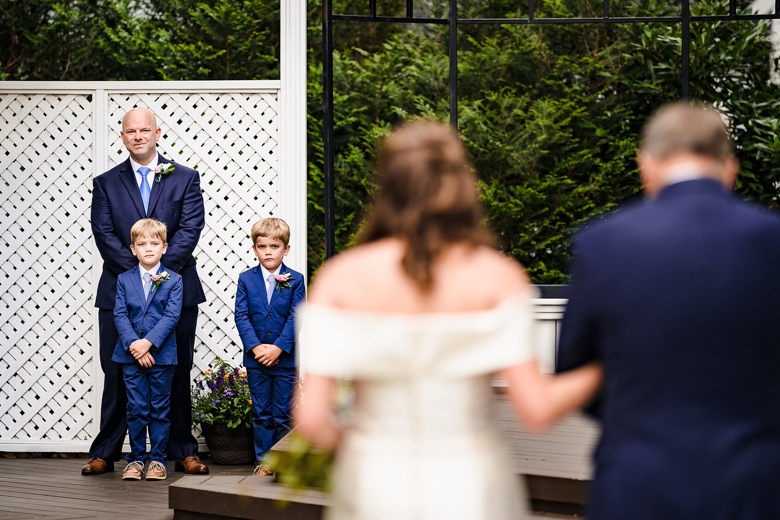 Groom smiles as bride walks down the aisle at this Raleigh backyard wedding
