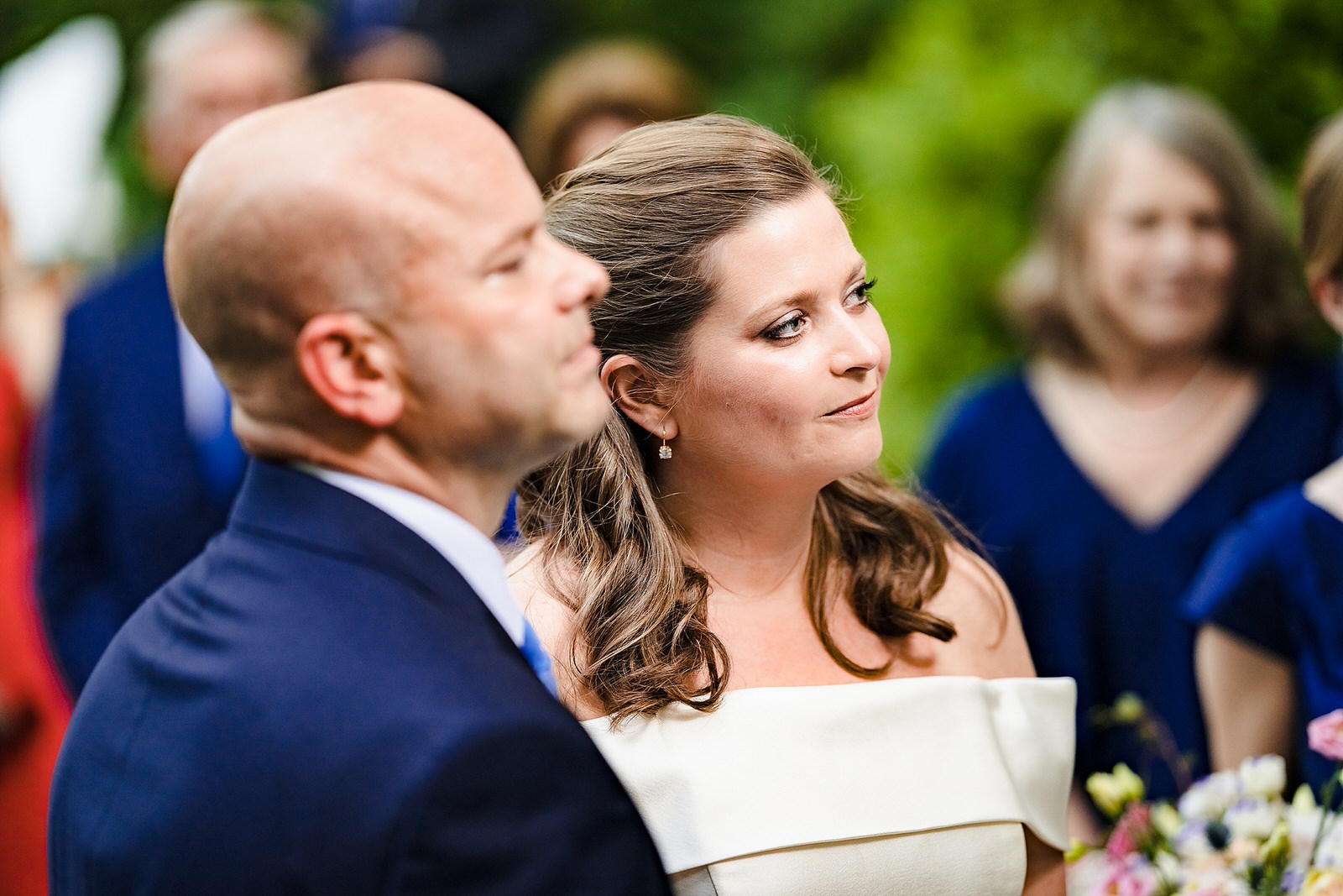 Bride and groom listen to pastor speaking about love during wedding ceremony