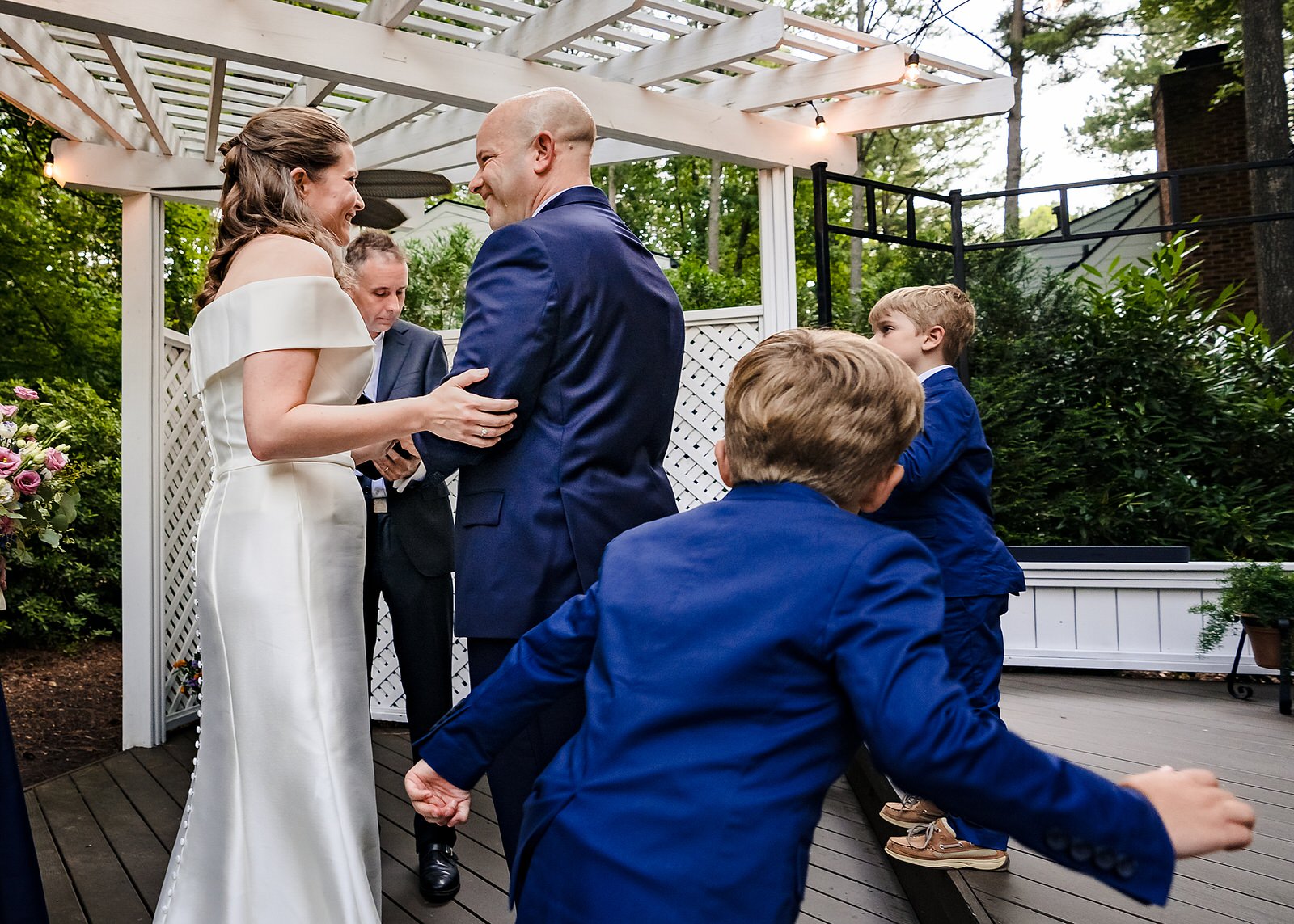 Groom's sons run by the camera as the couple exchanges rings