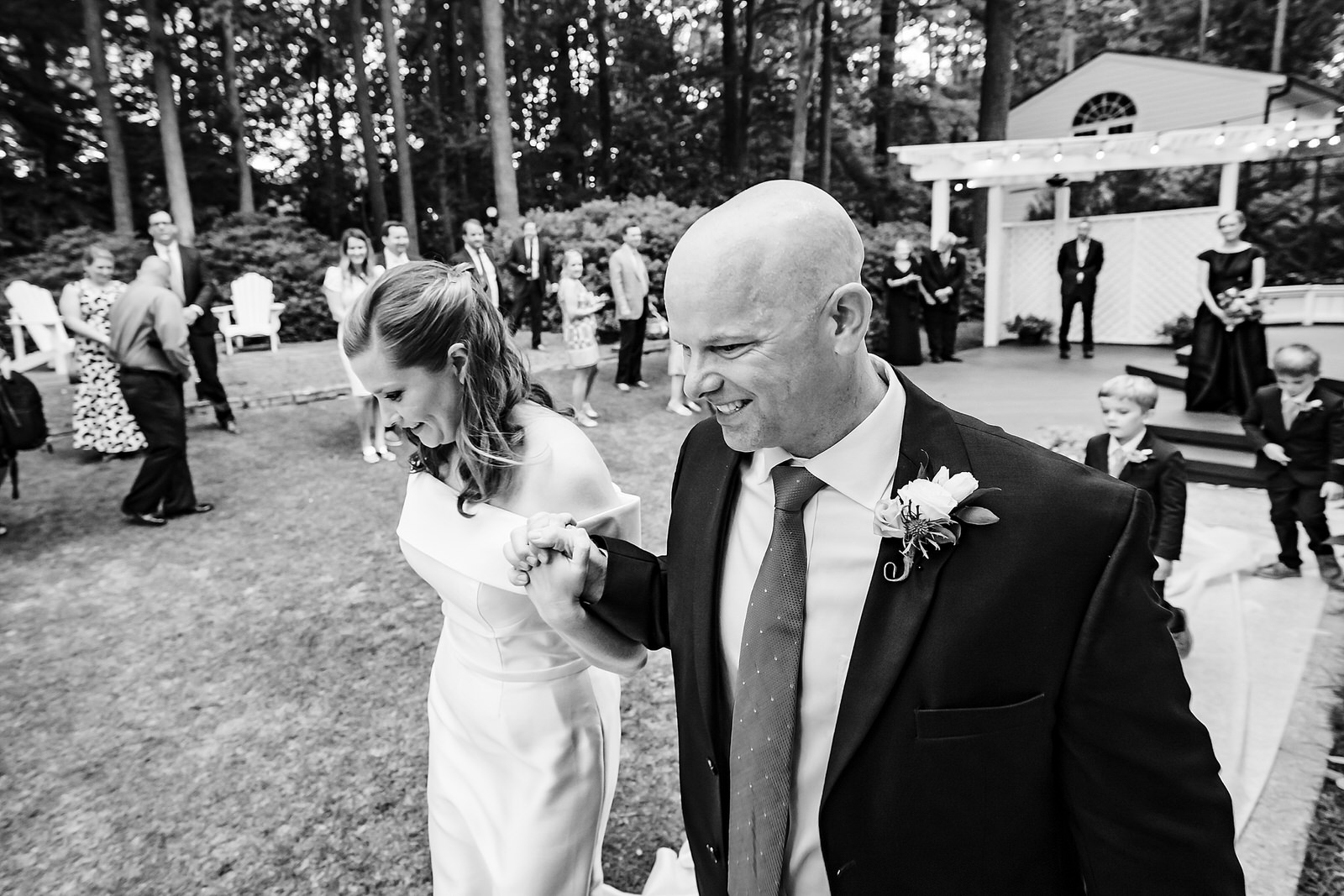 Bride and groom smile and process out of wedding ceremony at Raleigh micro-wedding
