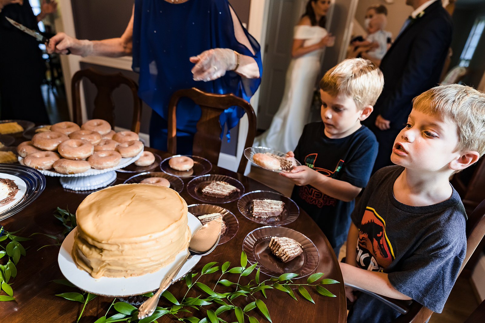 Groom's sons look at wedding cake and donuts excitedly