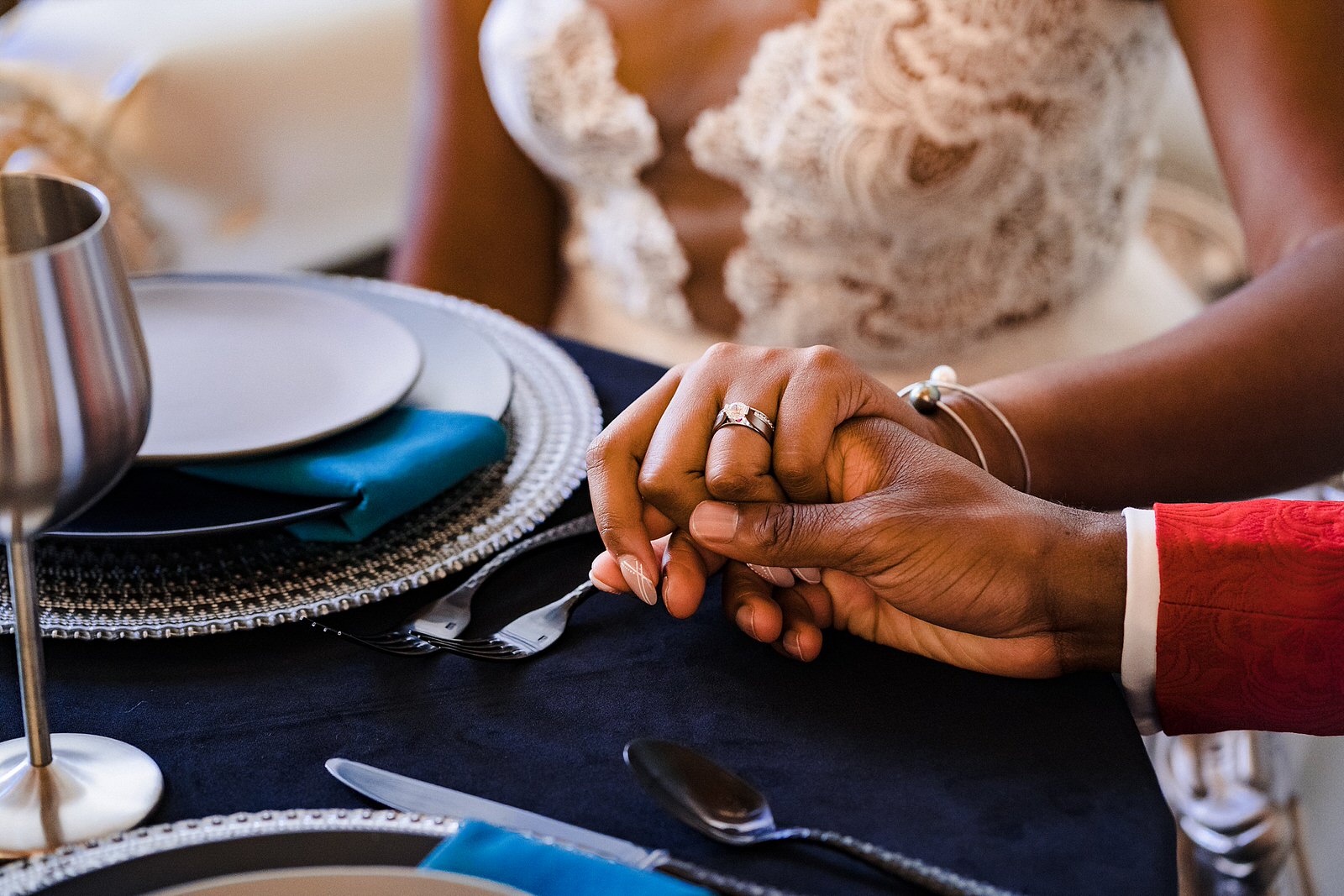 Closeup of couple holding hands at a wedding sweetheart table