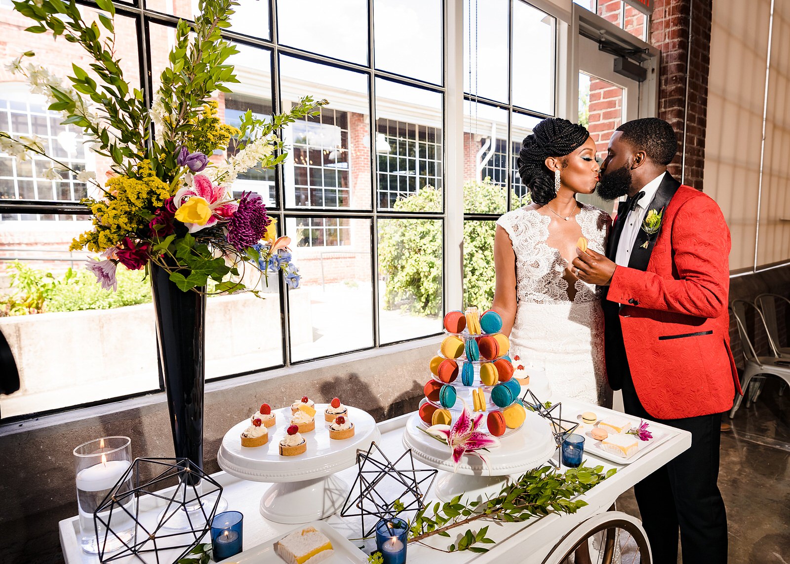 Wedding couple stands next to a dessert table filled with treats from Sugar Euphoria