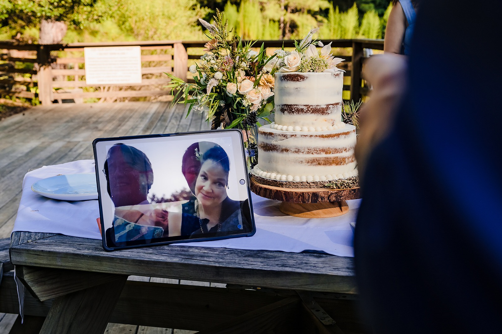 Bride and groom look at an ipad, where their families are toasting them via zoom during a covid19 chapel hill elopement