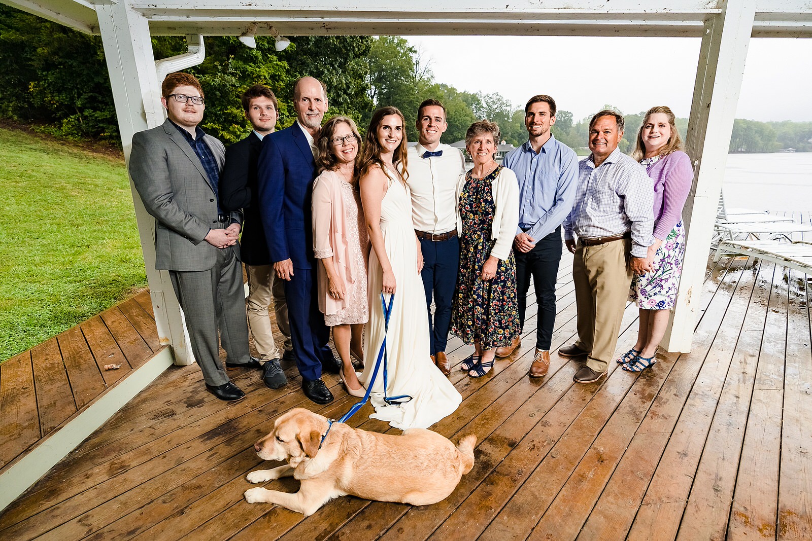all guests in attendance pose for a picture after an intimate backyard wedding ceremony