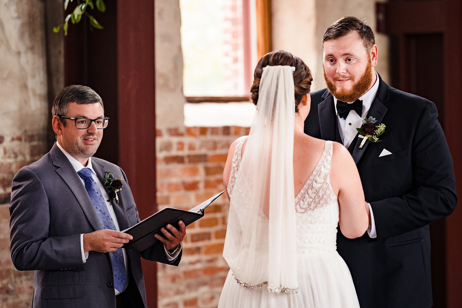 Groom looks lovingly at bride as they exchange personalized wedding vows