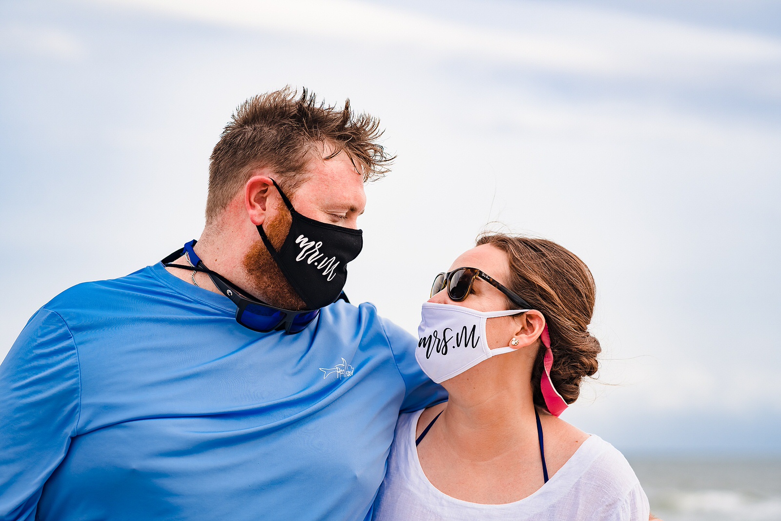 Bride and groom wear mr. and mrs. face masks at their casual beach wedding reception after their original plans were derailed due to Covid19