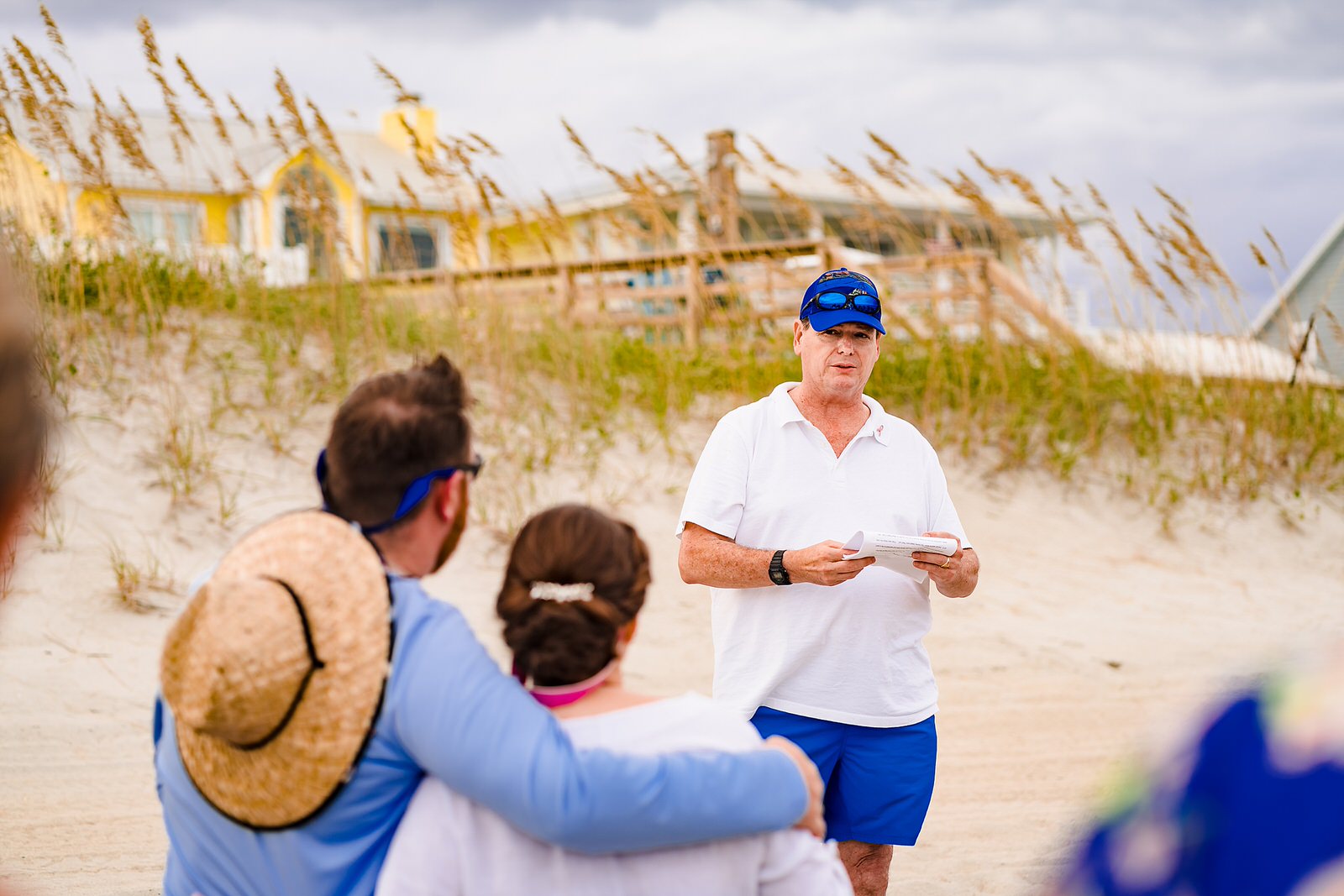 father of the groom gives a toast during a casual beach wedding reception