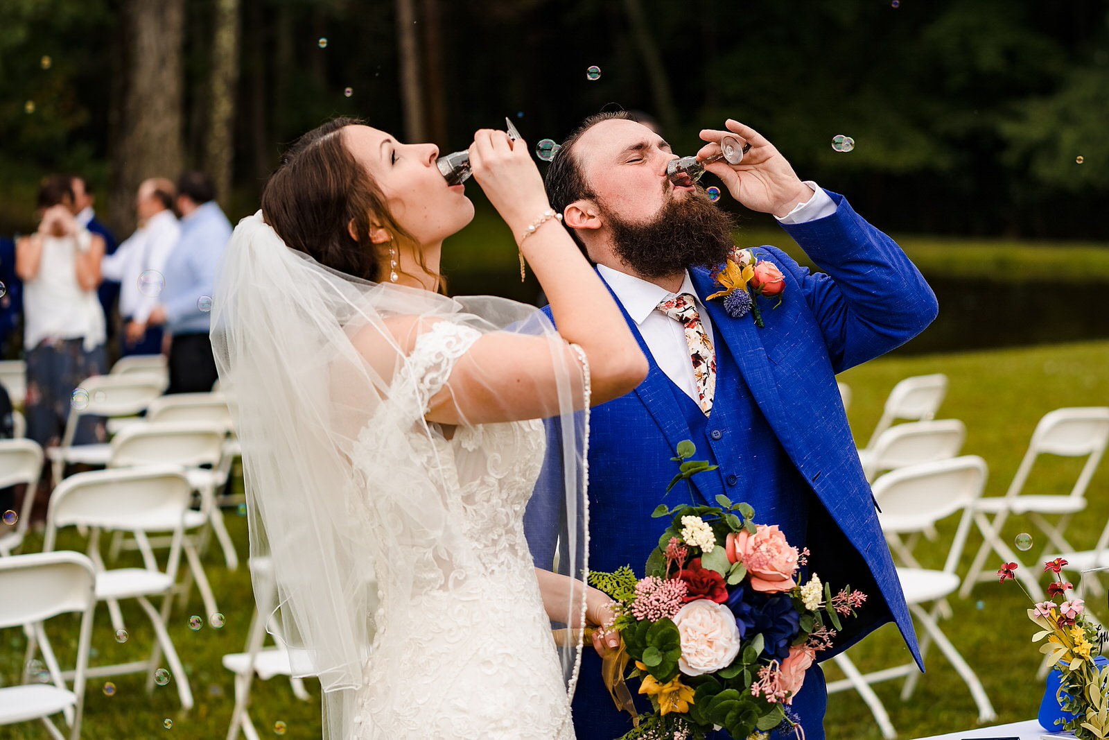 Bride and groom take a shot together at the end of their wedding ceremony
