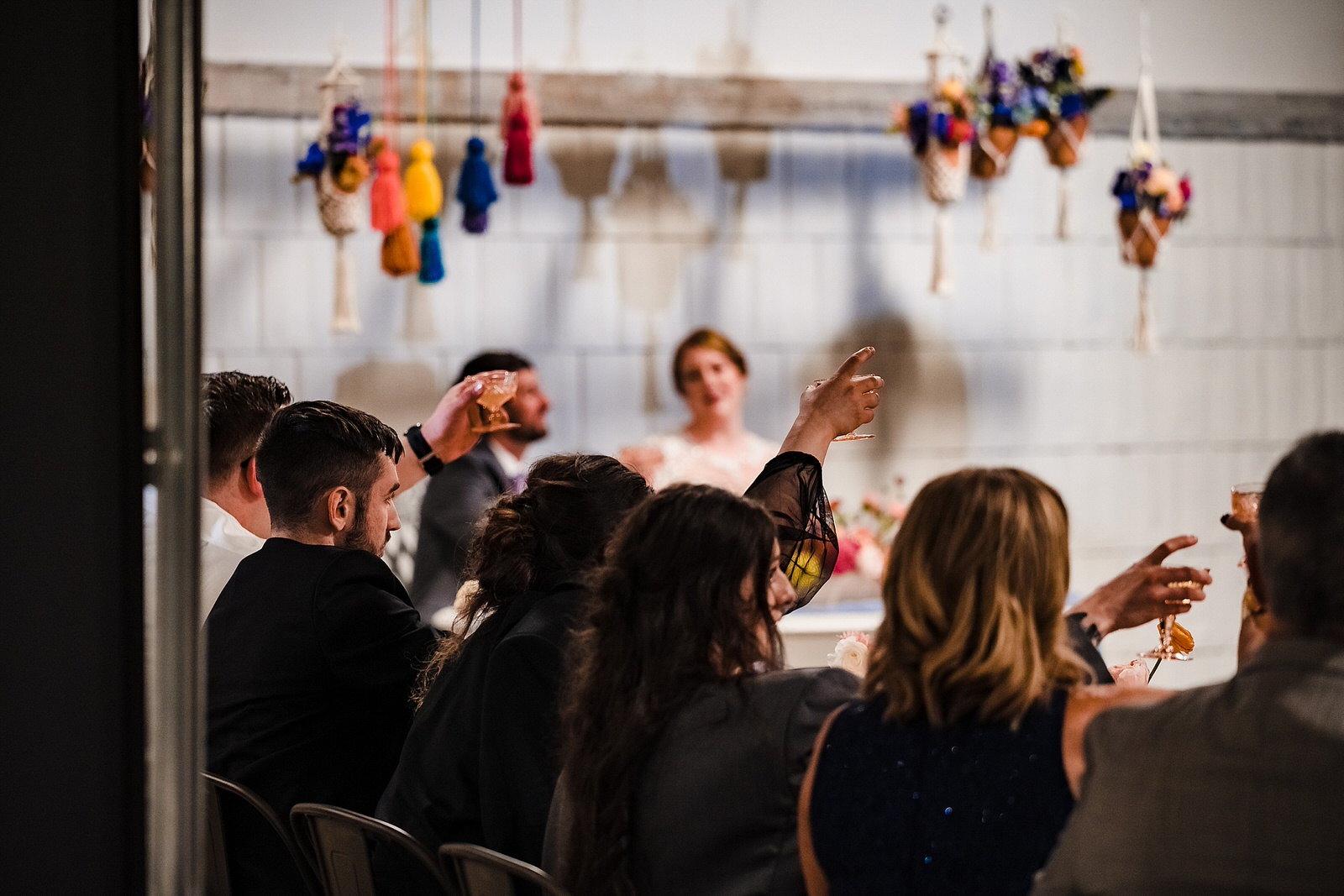Guests raise their glasses for a toast at this colorful wedding reception