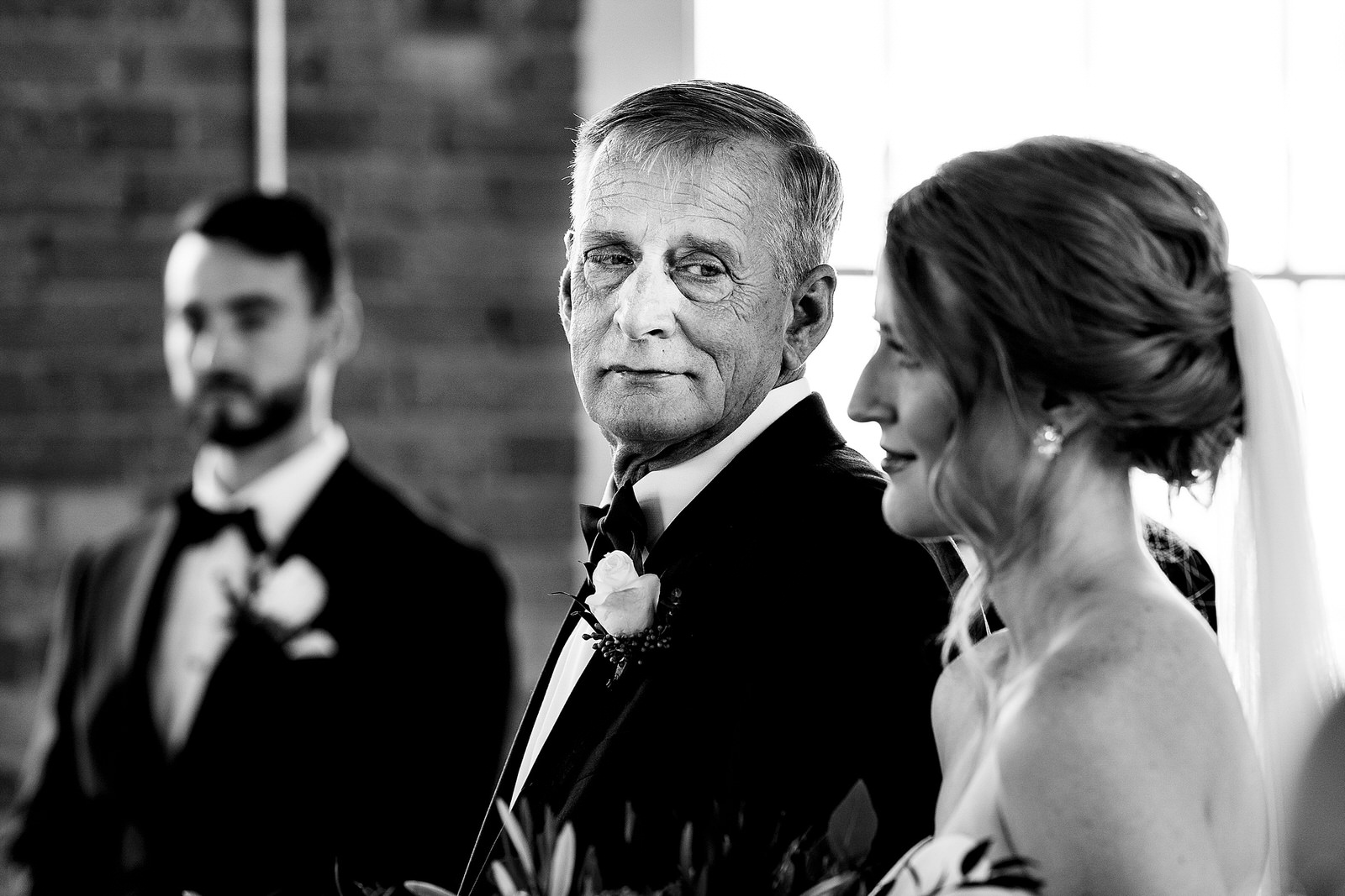 Father of the bride takes one last look after walking her down the aisle