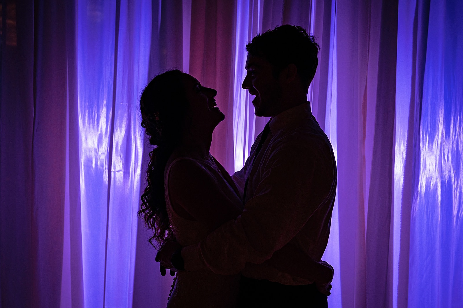 newlyweds silhouetted against a purple backdrop | colorful and creative wedding photography by Kivus & Camera