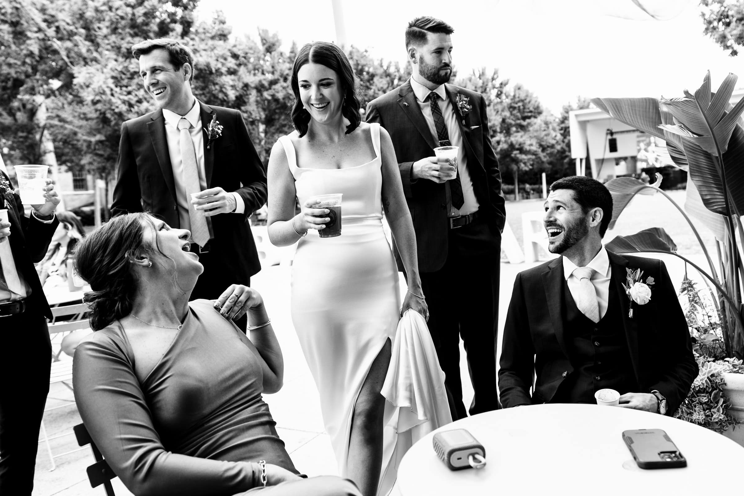 a couple in wedding attire laughs with their friends | photos by Kivus & Camera
