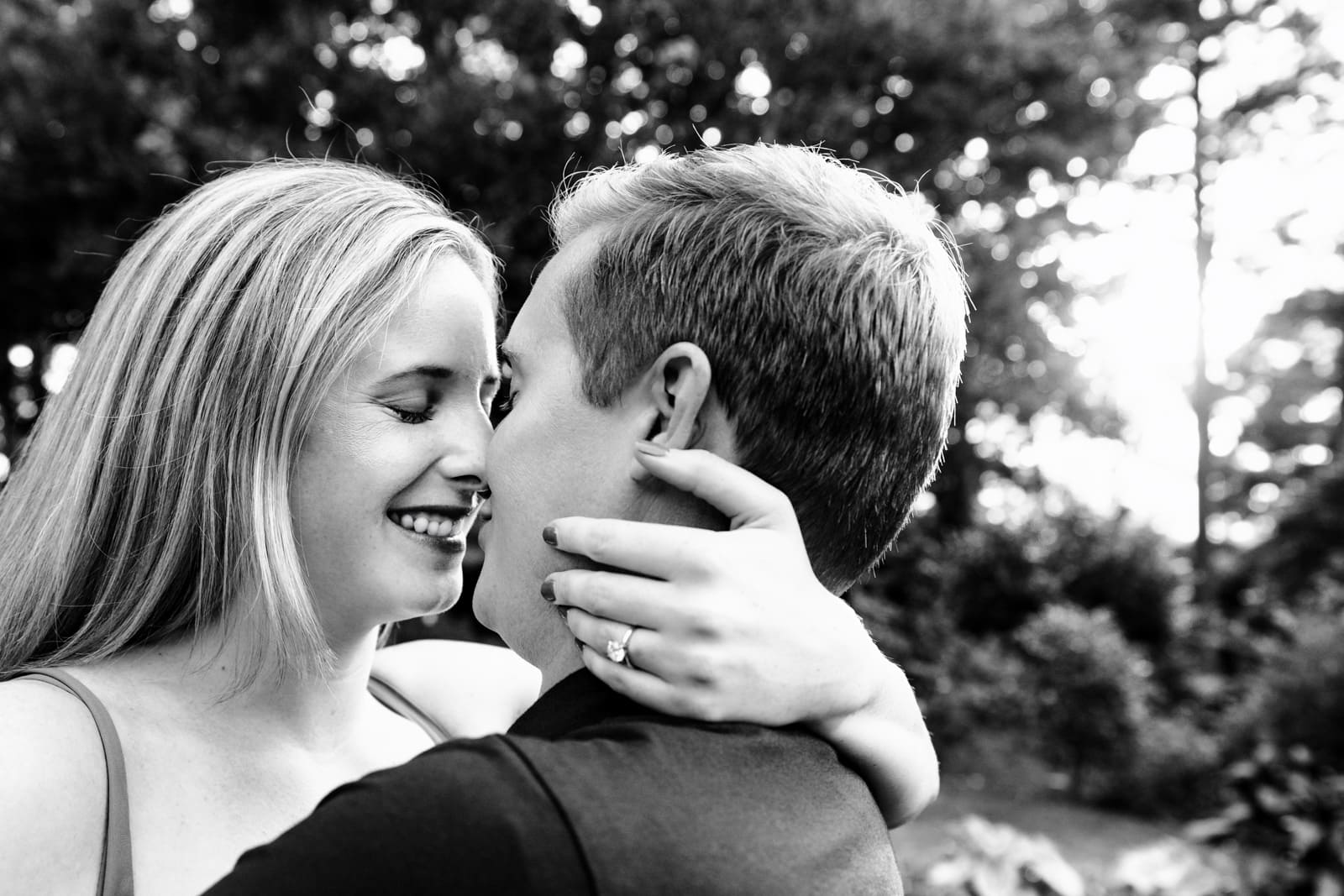 engaged couple embraces in a black and white photo creative engagement photography at Killjoy Cocktail bar in Raleigh, NC | photos by Kivus & Camera