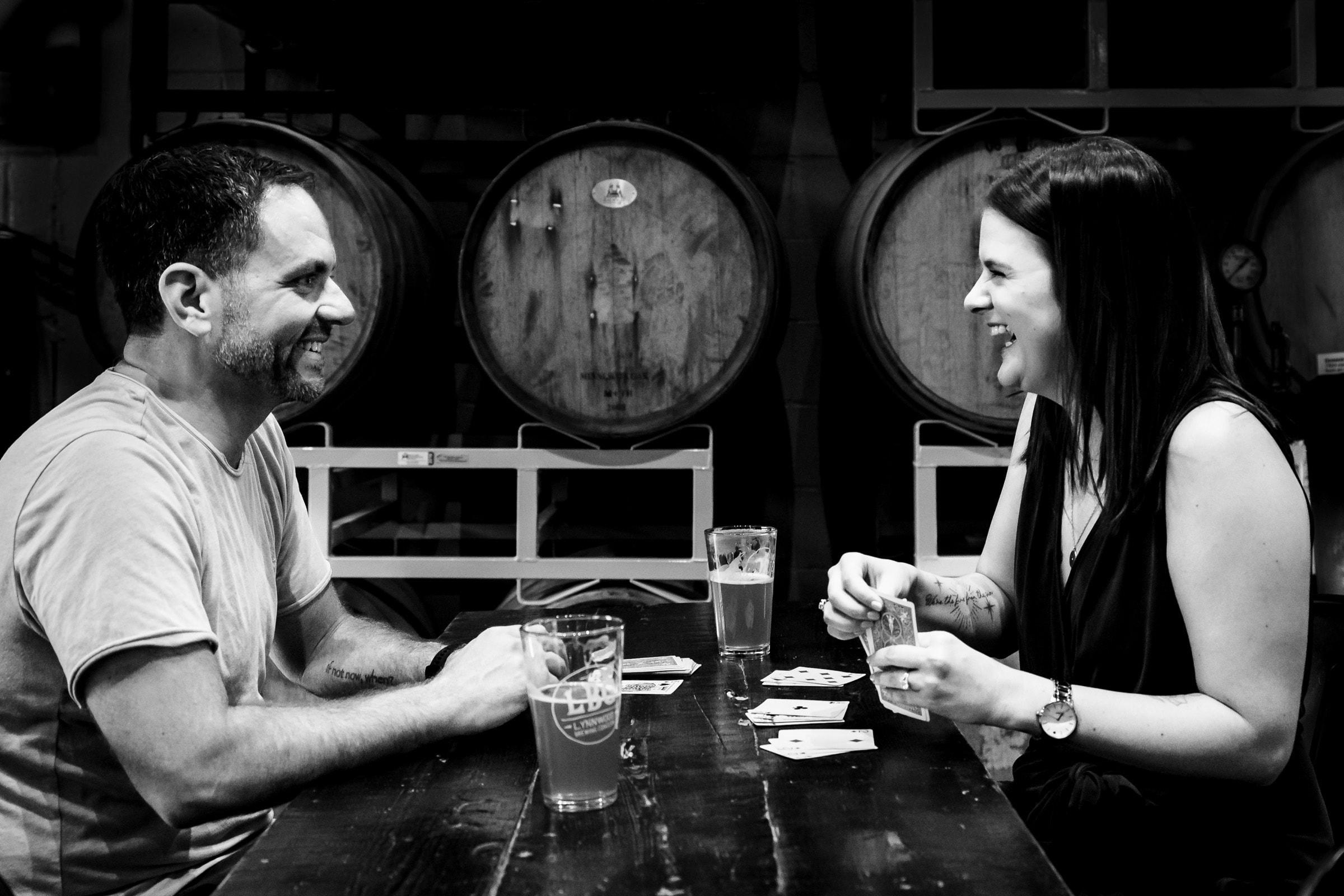 man and woman smile across a table at one another as they play cards