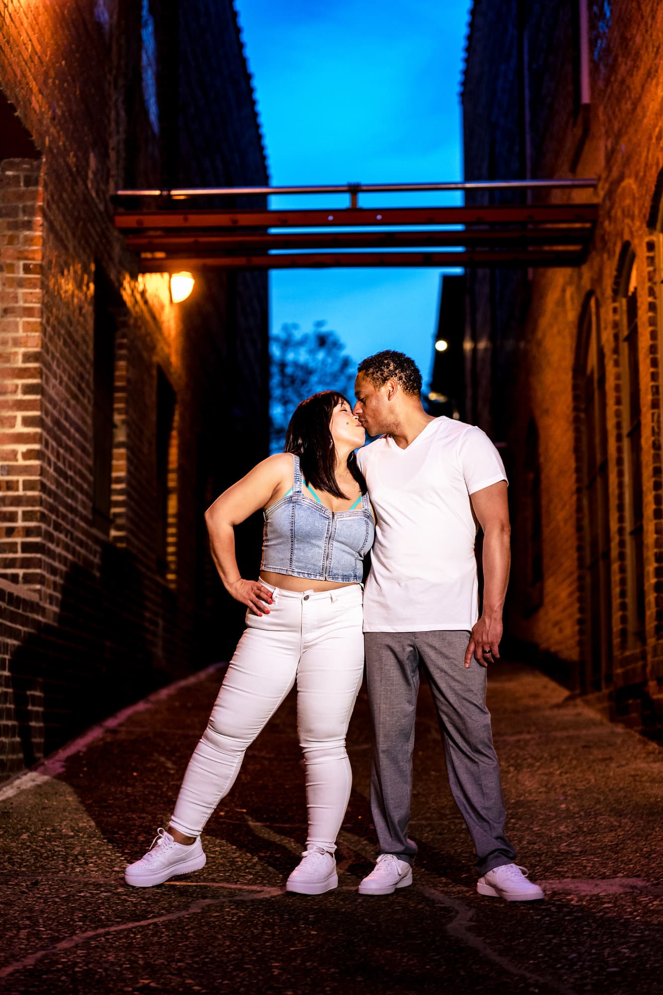 couple kisses in a brick alleyway in the warehouse district in Raleigh, NC