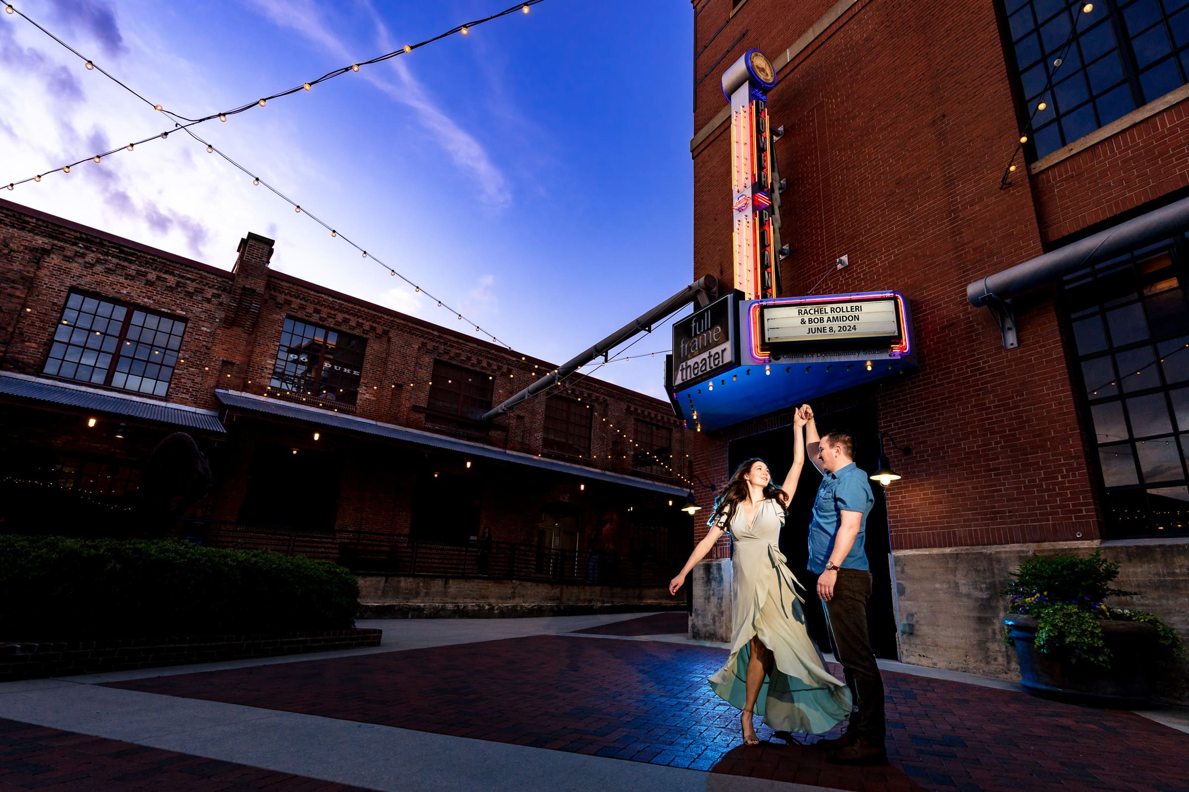 couple dances in front of a marquee at American Tobacco Campus