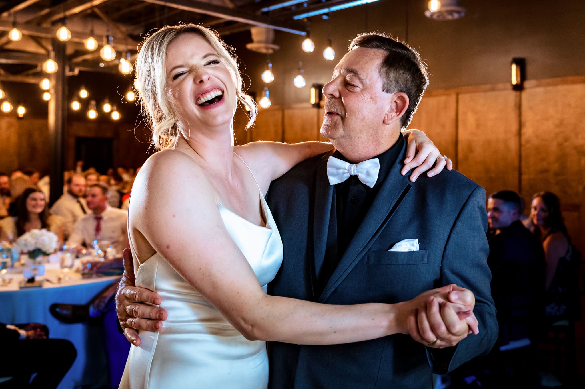 bride laughs as her father looks at her during the father daughter dance | photo by Kivus & Camera