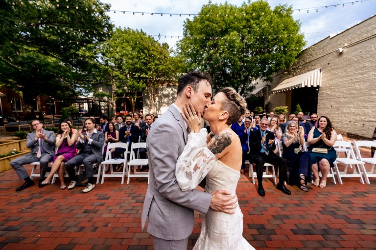 couple shares their first kiss at their grove at city market wedding ceremony