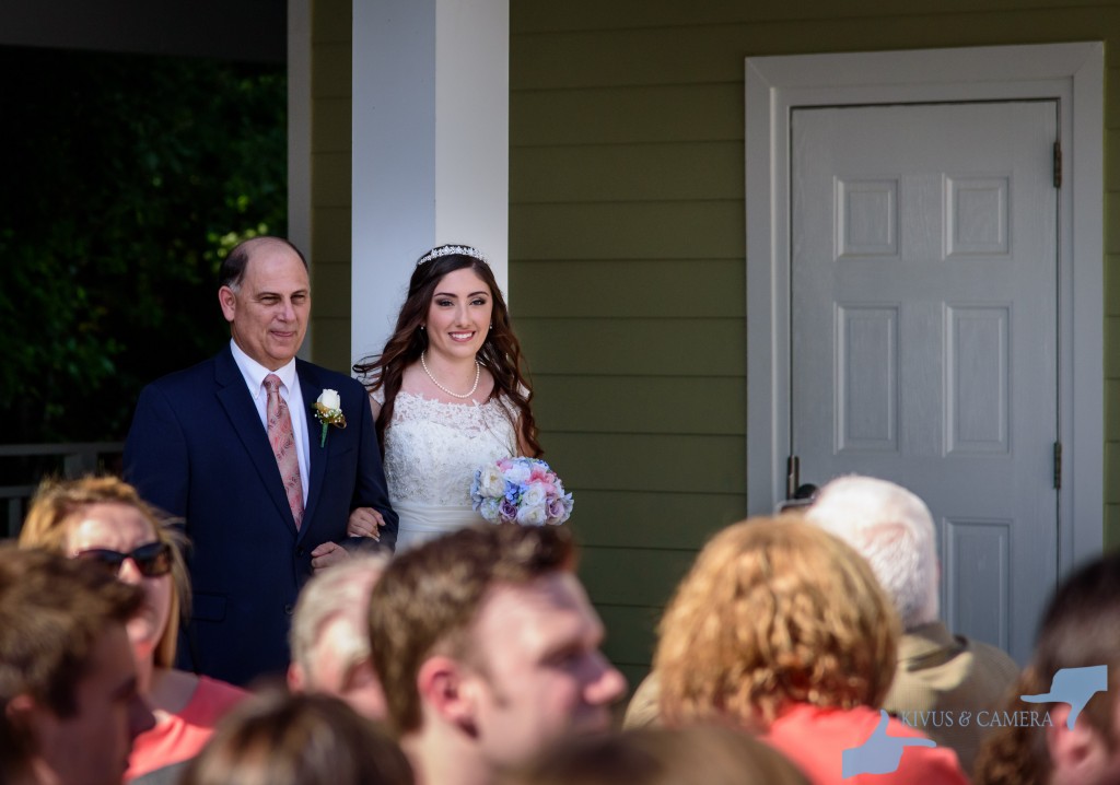 Bride walks down the aisle with her father.
