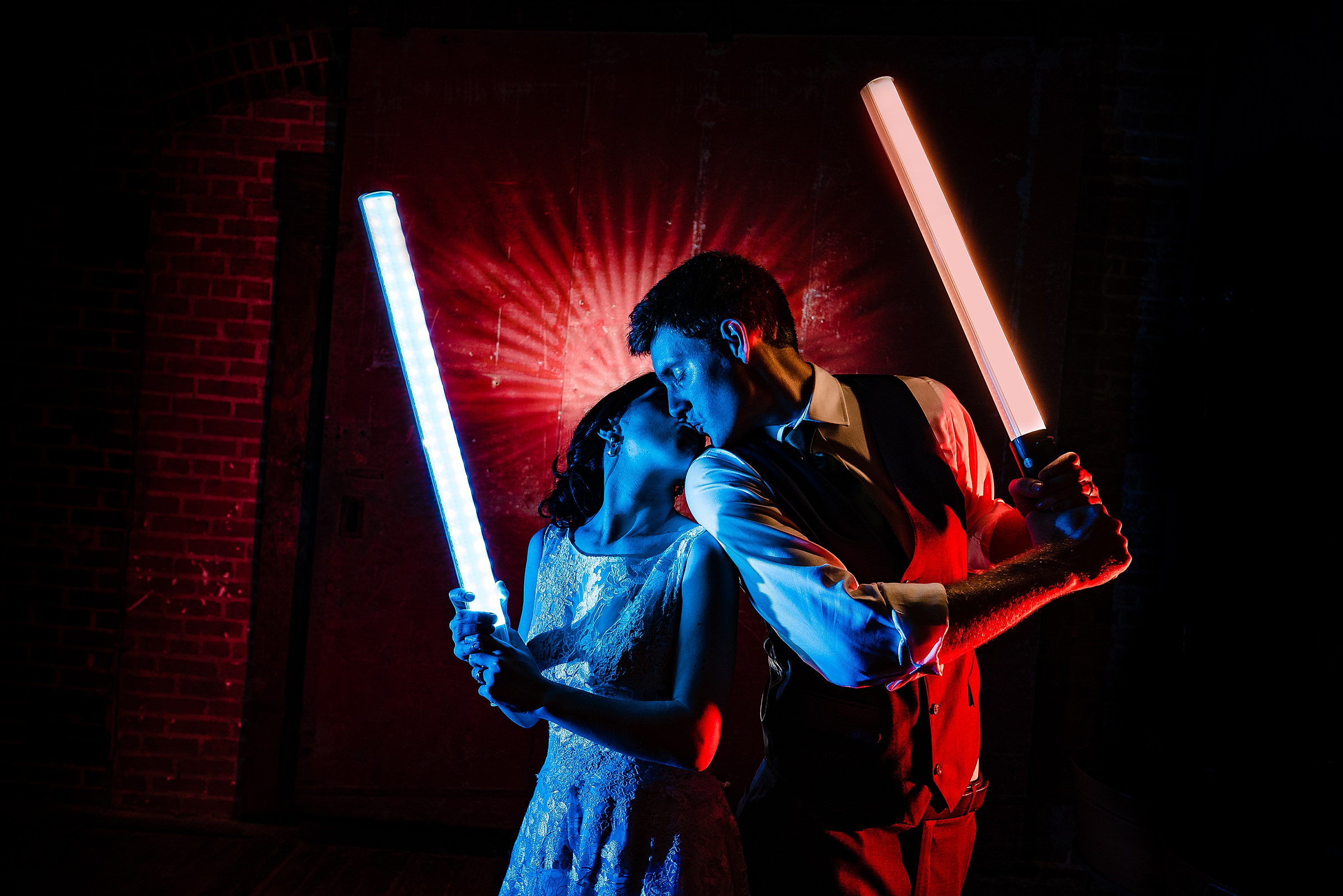 Bride and Groom pose with Light Sabers | Star Wars Wedding in North Carolina at Centennial Station in High Point | kivusandcamera.com