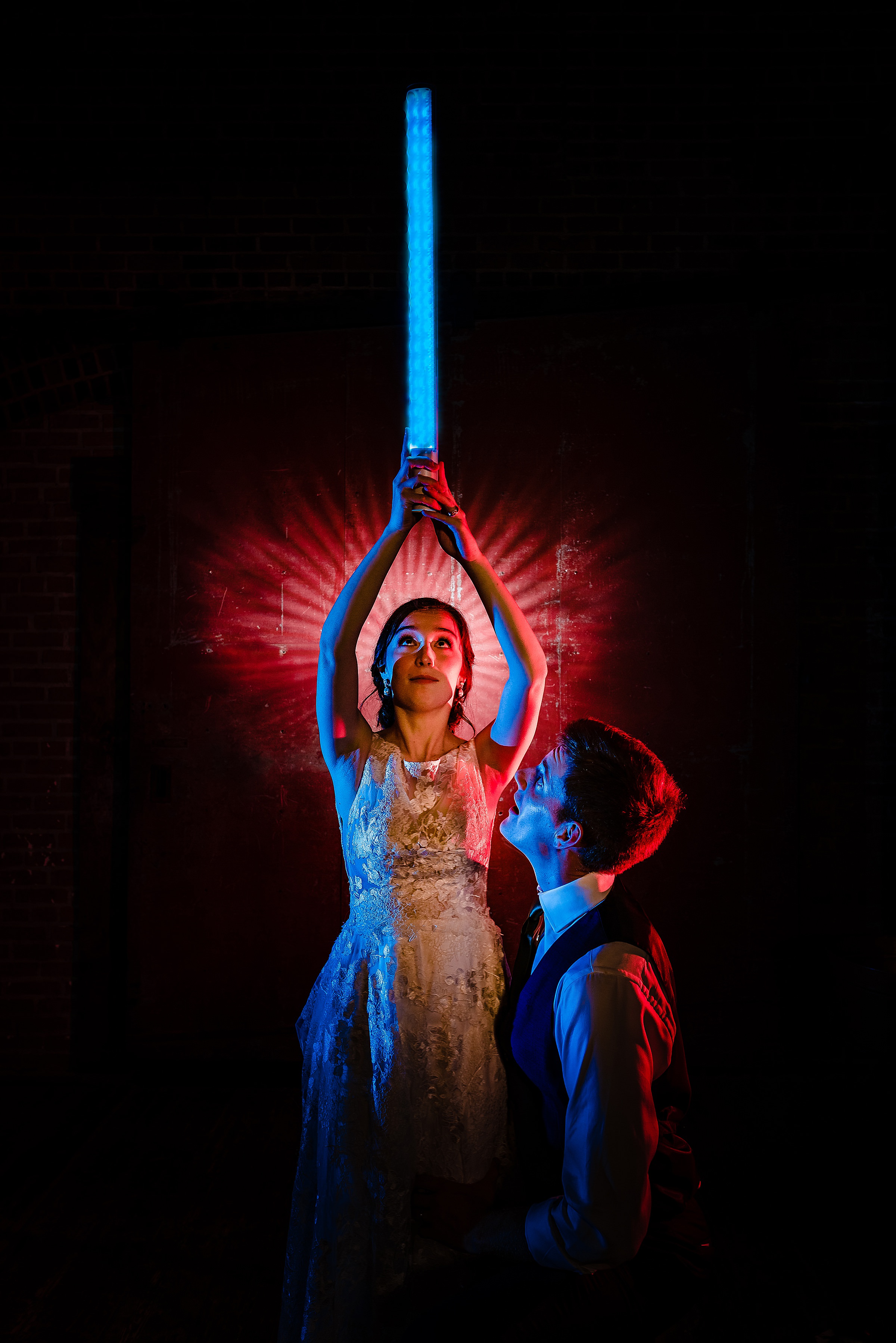 Bride and Groom pose with Light Sabers | Star Wars Wedding in North Carolina at Centennial Station in High Point | kivusandcamera.com
