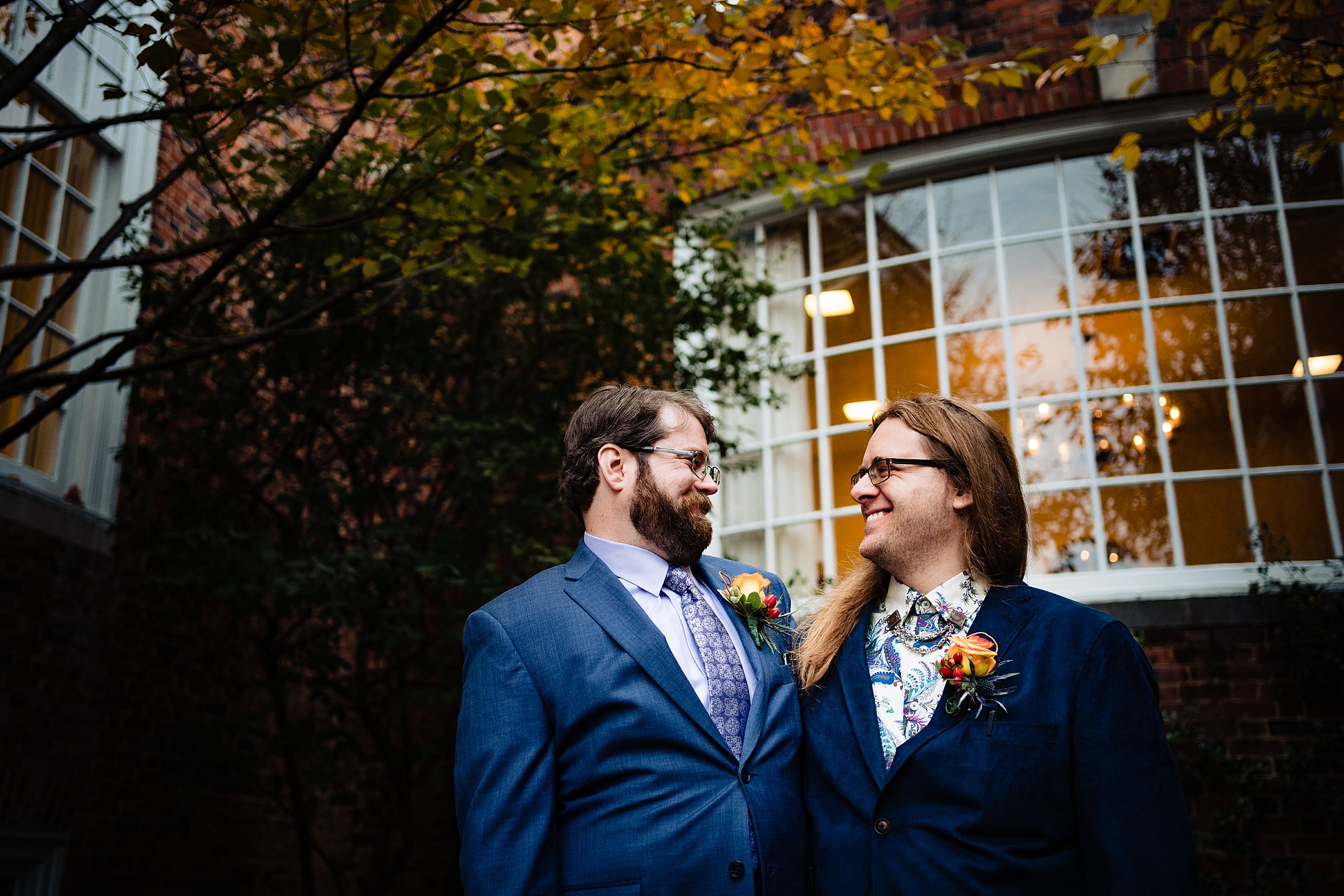 Two grooms smile at one another after their wedding with Raleigh wedding photographer