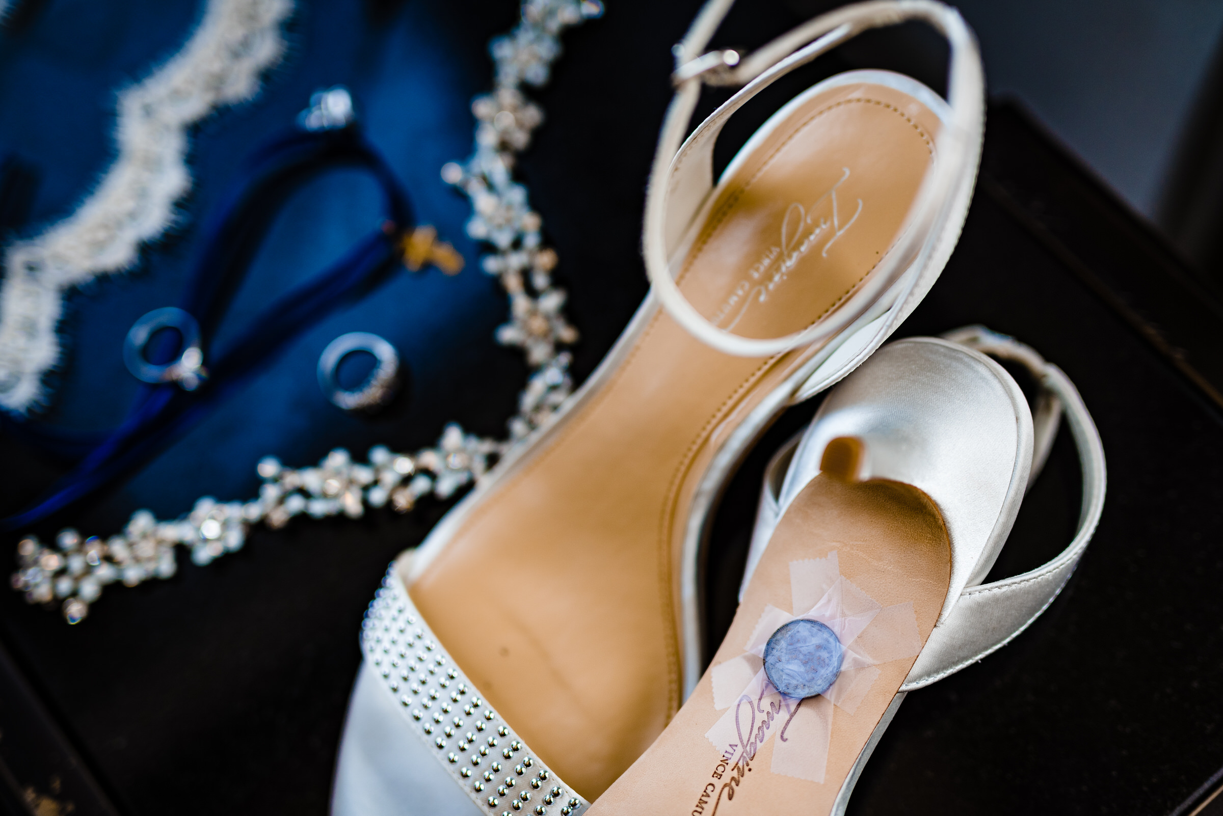 Photograph of a bride's wedding details including a sixpence taped to the bottom of one of her shoes