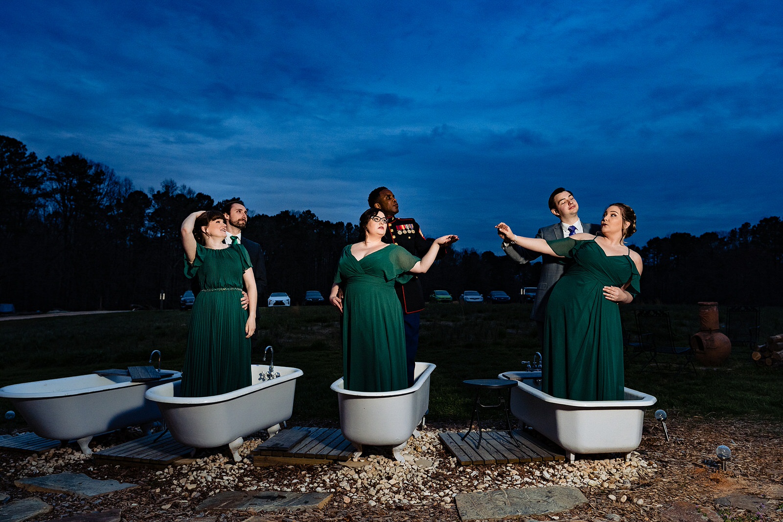 Members of the wedding pose dramatically in bathtubs at The Meadows Raleigh