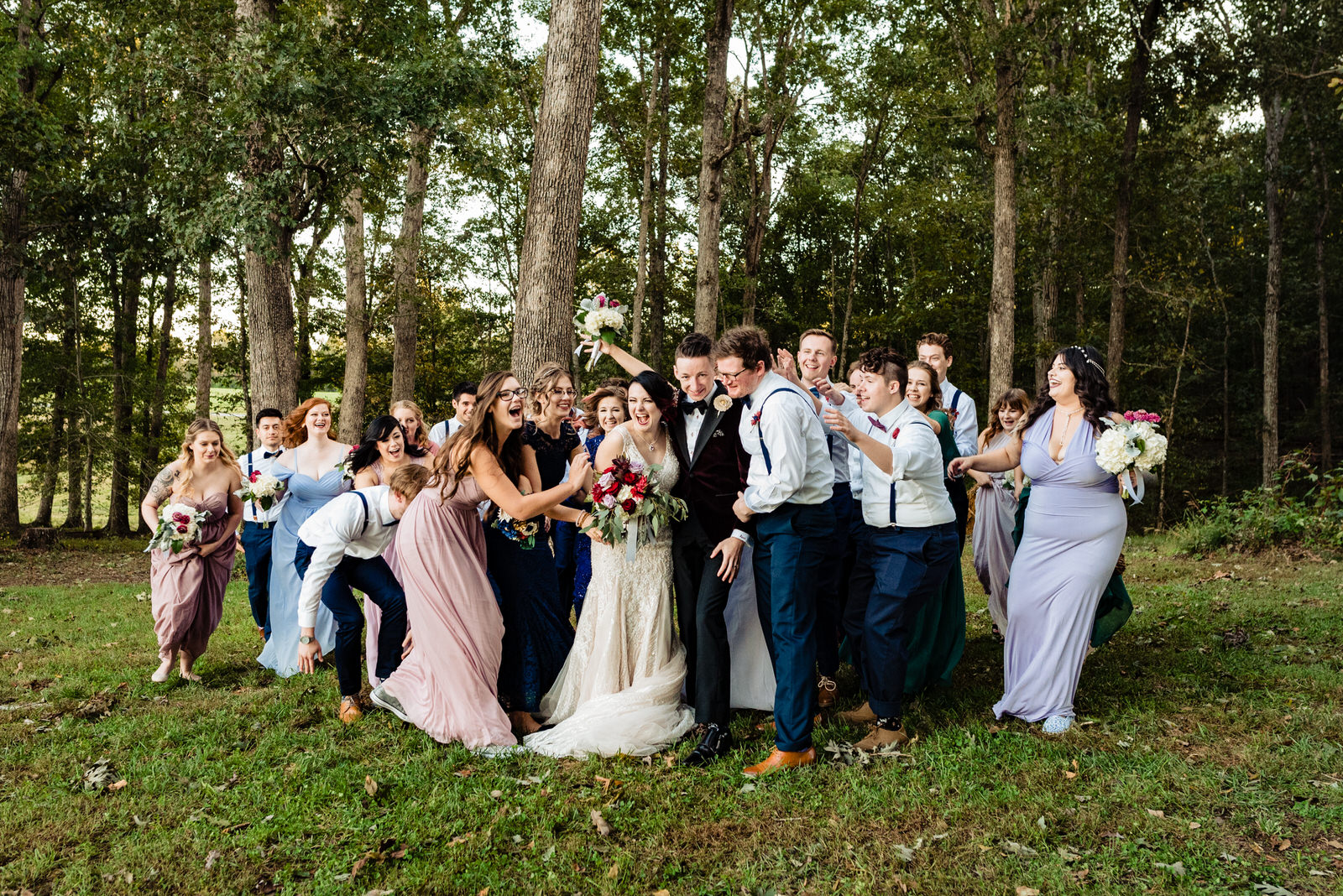A bride and groom are surrounded by their friends for a group hug on their wedding day
