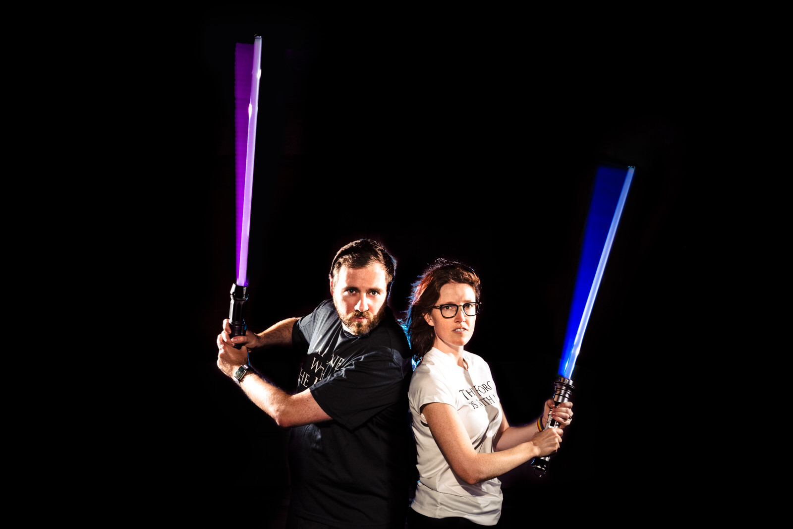 Nerdy wedding photographers pose with their light sabers