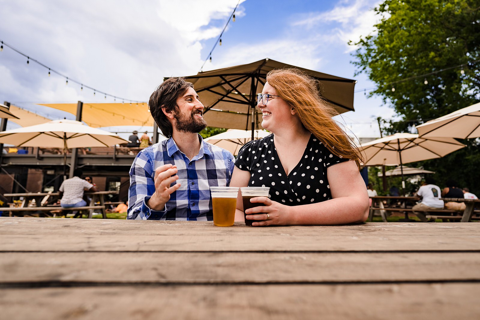 An engaged couple laughs over beers at Durham Brewery Ponysaurus