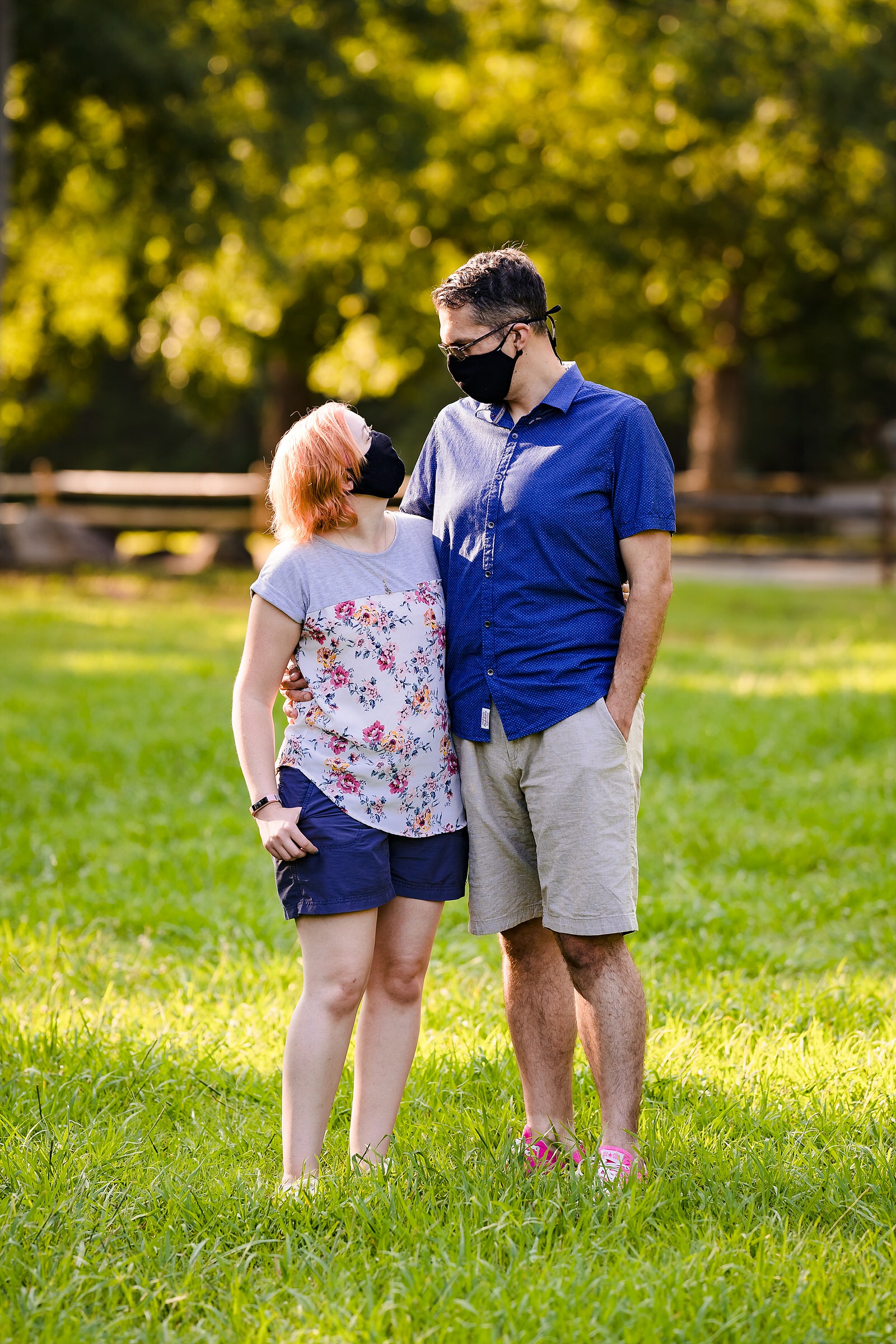 A man and a woman, both wearing Covid19 masks, look at one another during their Durham engagement photo session