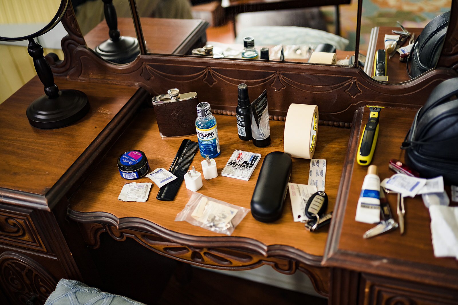 The groom's necessities set out on a desk in his getting ready area