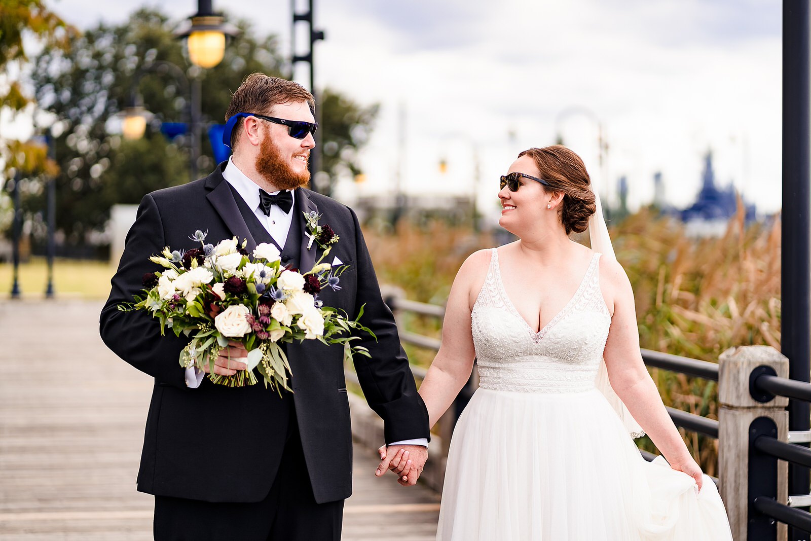 Bride and groom walk down the riverwalk in Wilmington, NC after their Brooklyn Arts Center wedding
