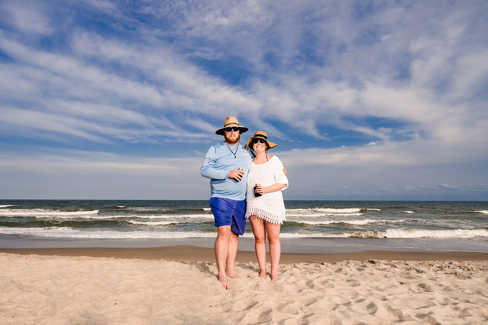 Bride and groom pose in their beach attire at Kure Beach during a casual wedding reception after a ceremony at the Brooklyn Arts Center