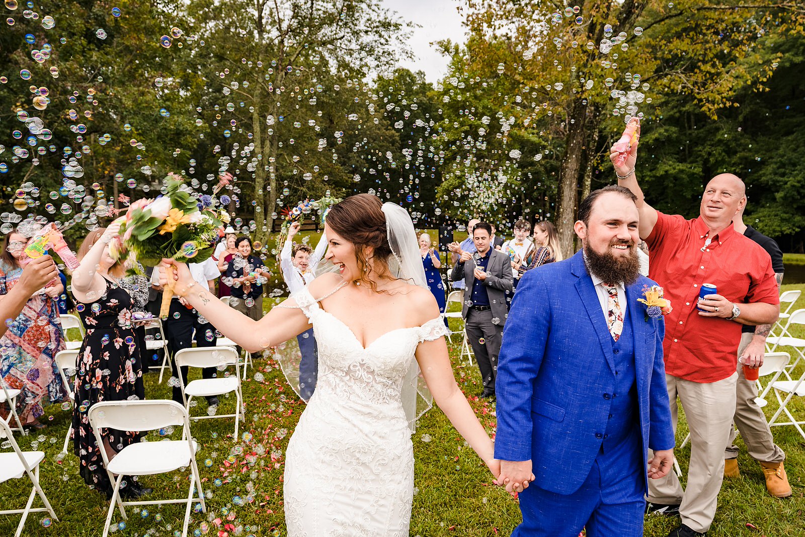Bride and groom recess down the aisle to bubbles after their wedding ceremony
