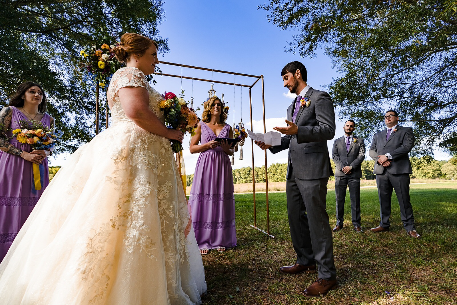 Groom reads his personal vows during outdoor wedding ceremony