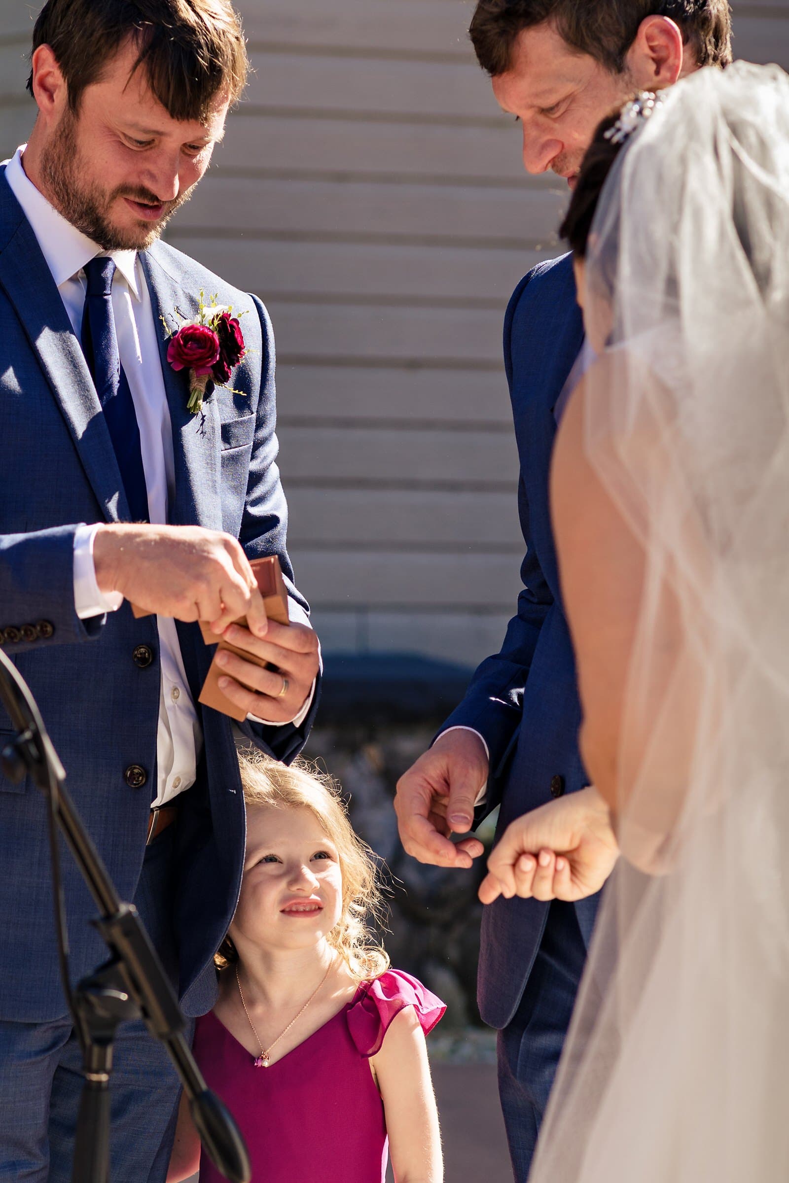 Best Man's daughter looks on as he hands over the rings during this wedding ceremony