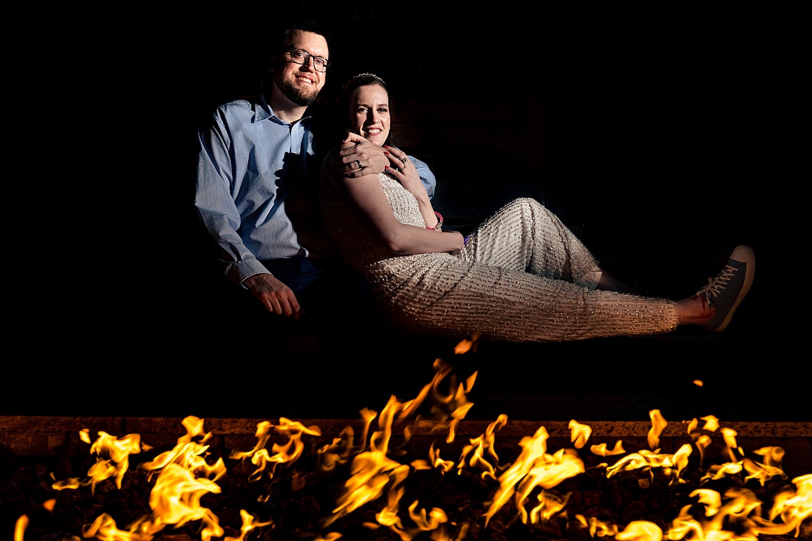 Bride, in a sparkly white jumpsuit, and groom enjoy a break from their wedding reception with a bonfire | NC wedding photographers Kivus & Camera