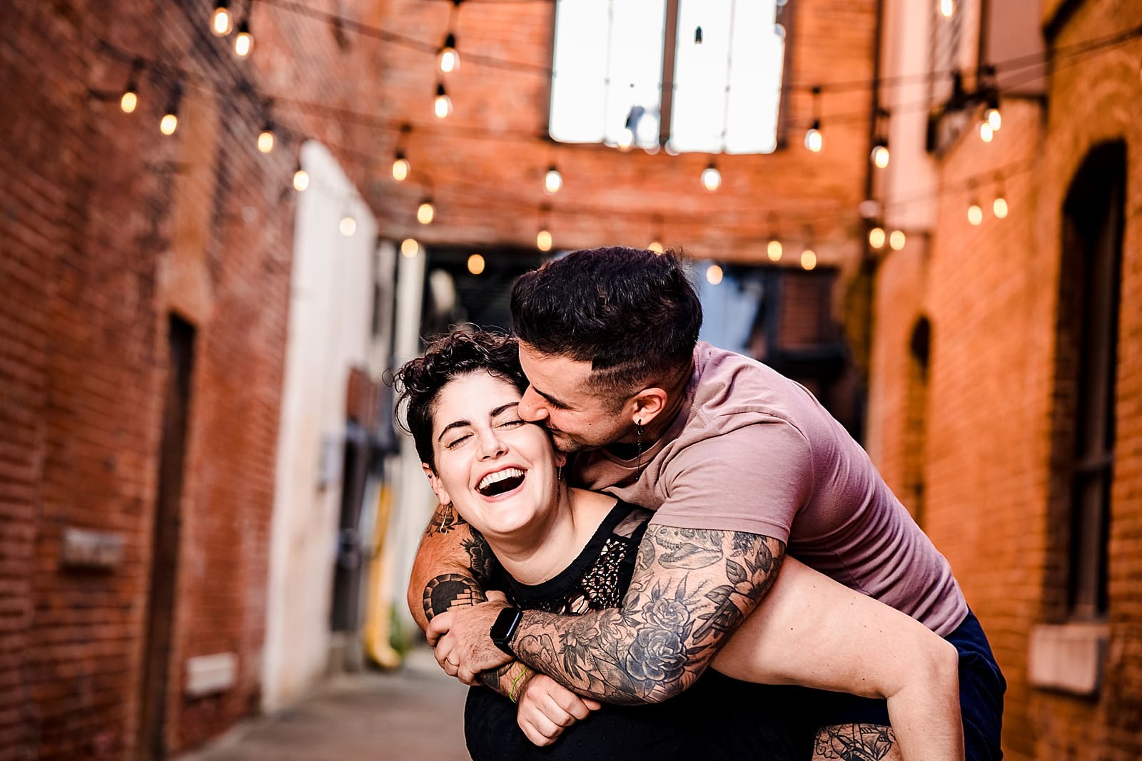 A couple embraces and laughs in Alley 26 in Downtown Durham