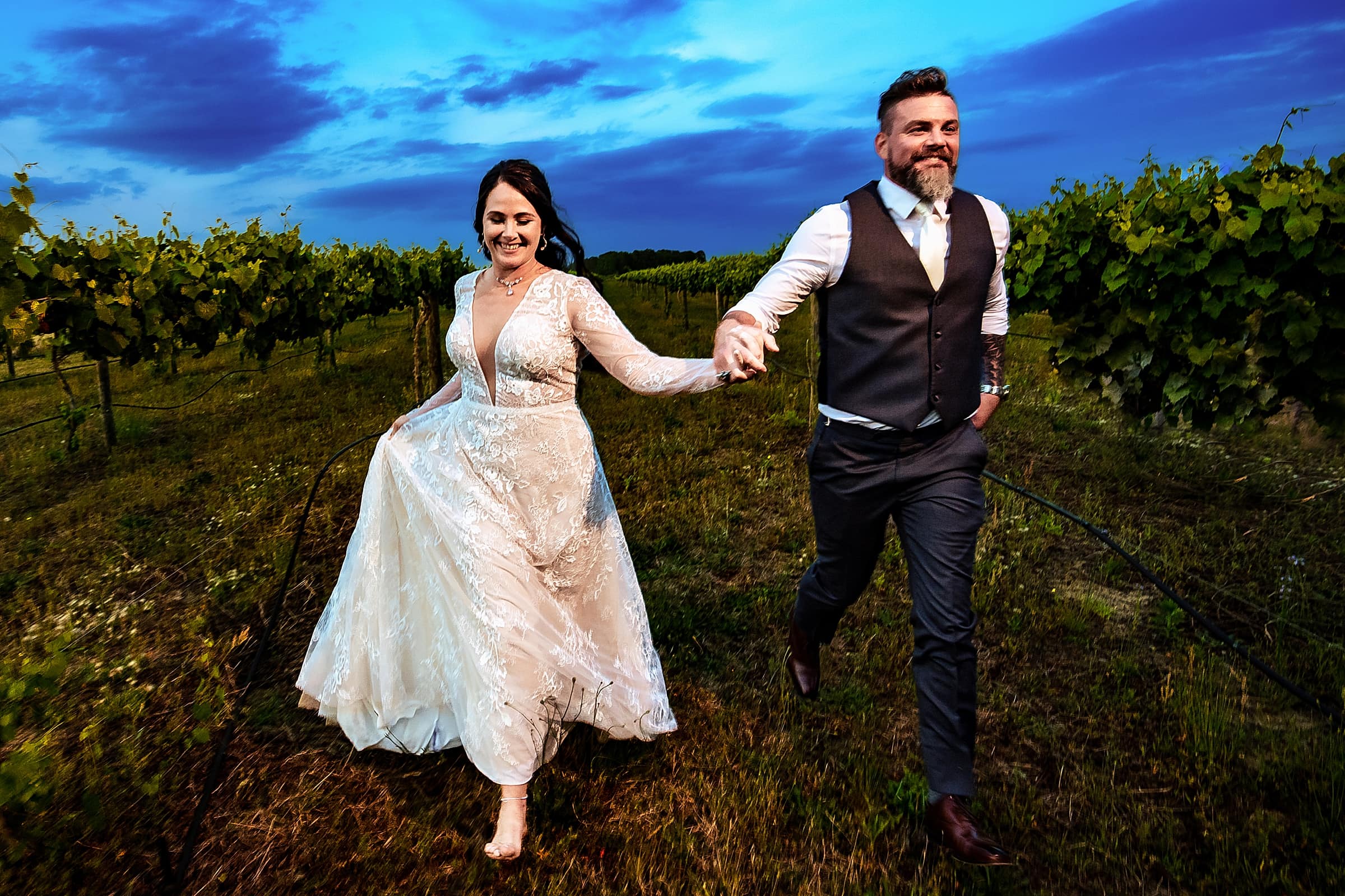 newlyweds run through vines at a rustic Vineyard Wedding in North Carolina