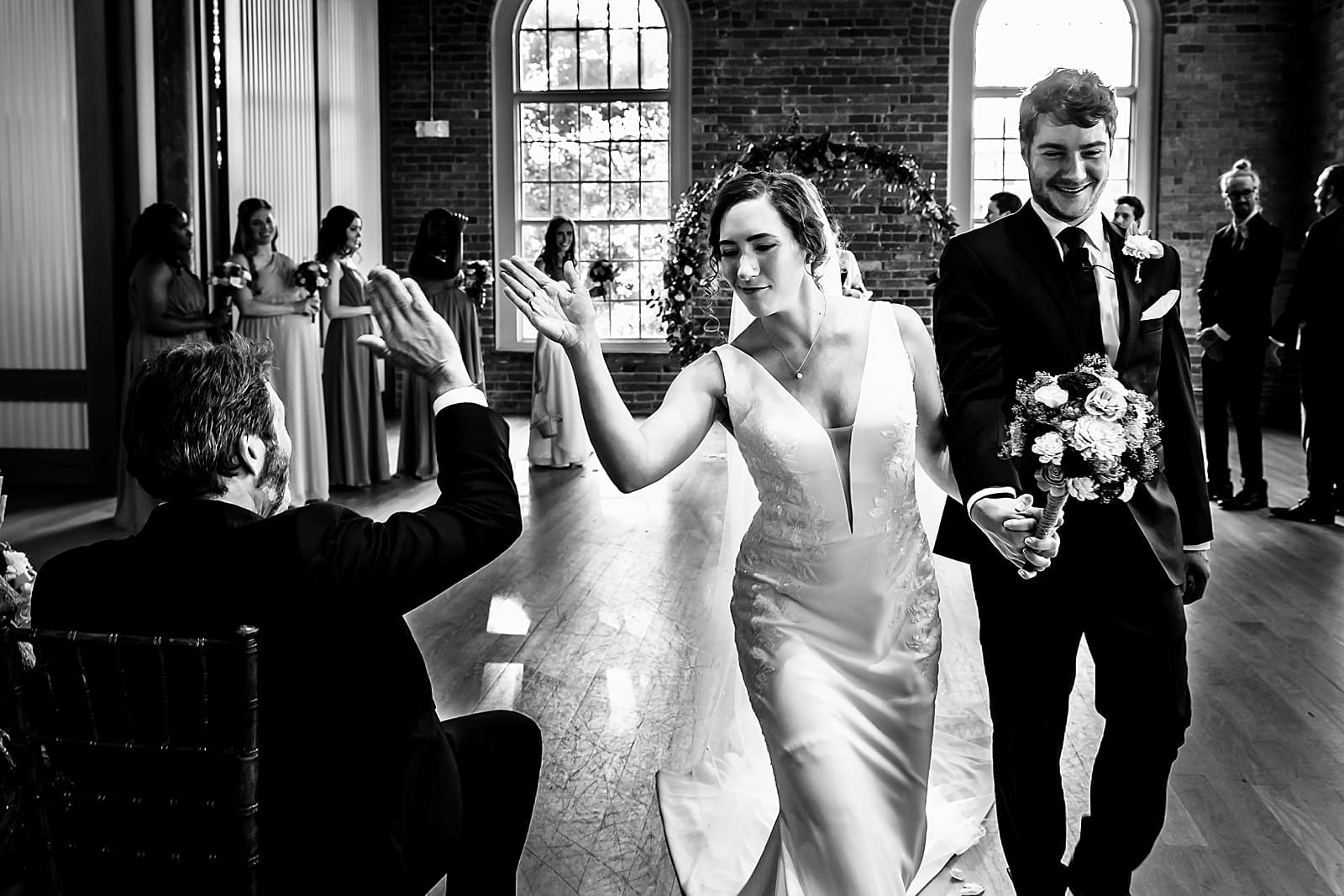 bride gives her dad a high five as the newlyweds recess out of the ceremony