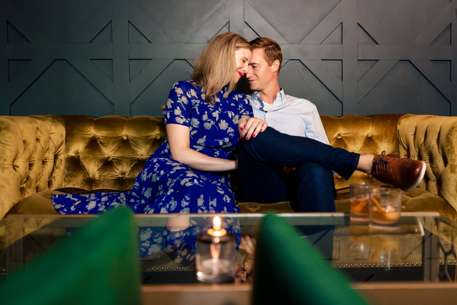 an engaged couple snuggles on a couch at Killjoy Cocktail in Raleigh | photos by Kivus & Camera