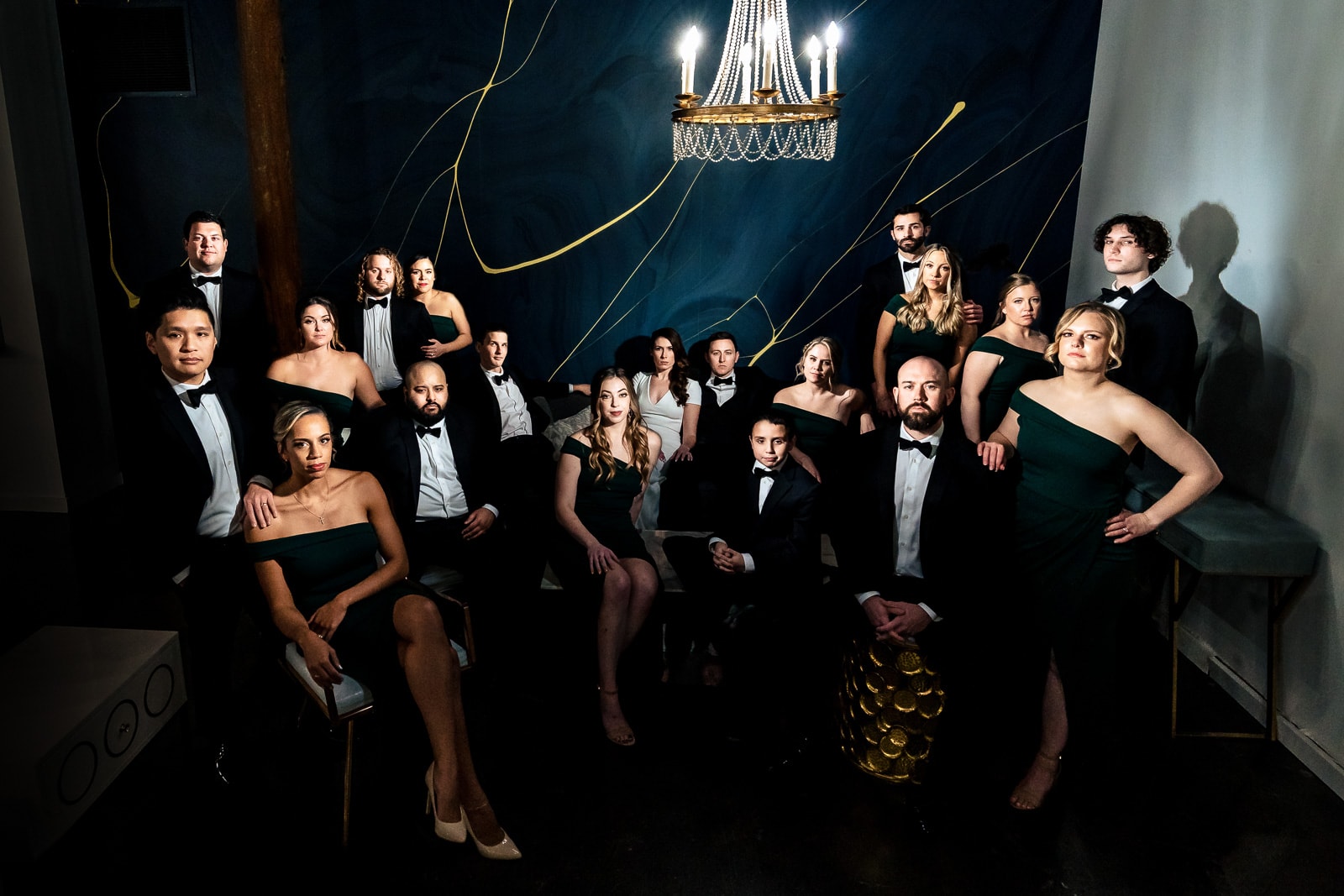 Dramatically lit composite photograph of a wedding party in tuxedos and dark green dresses at The Cotton Room in Durham, NC | photo by Kivus & Camera